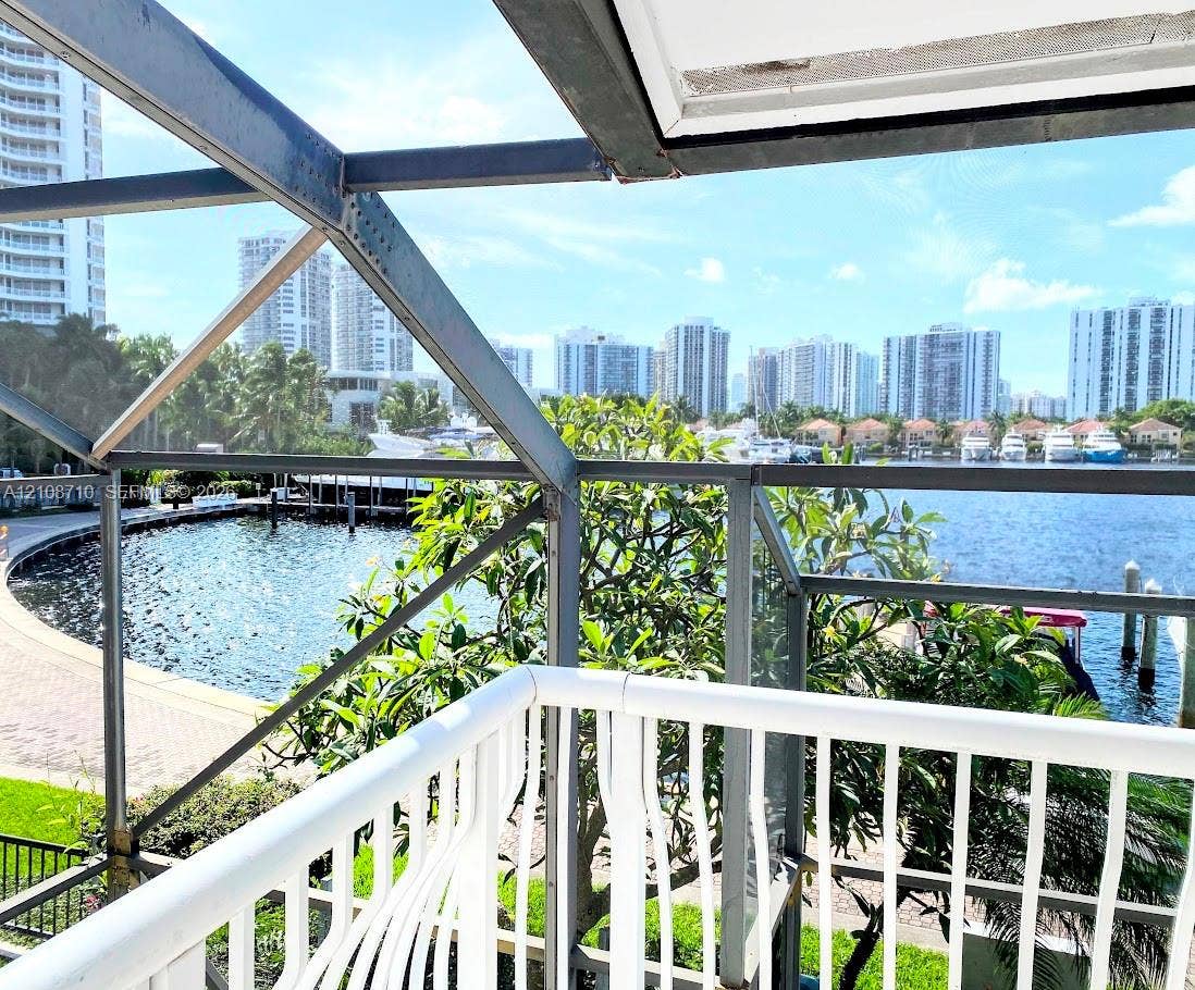 3630 Yacht Club Drive, #605, Aventura, Aventura, FL 33180 Enclosed balcony featuring a white metal railing, structural framing, and direct water exposure with a waterfront bulkhead