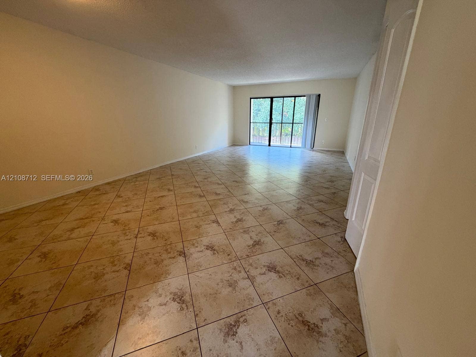 379 Lakeview Drive, #205, Weston, Weston, FL 33326 Interior space featuring diagonal-set tile flooring and a sliding glass door with a black frame