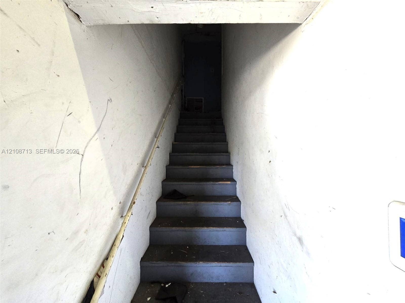 Staircase featuring painted wood treads and a mounted handrail