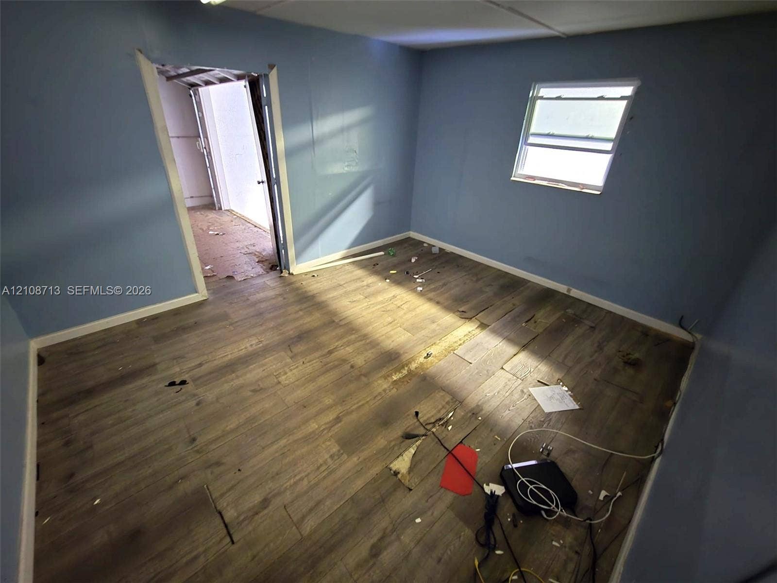 Interior room featuring wood-finish flooring and a single window