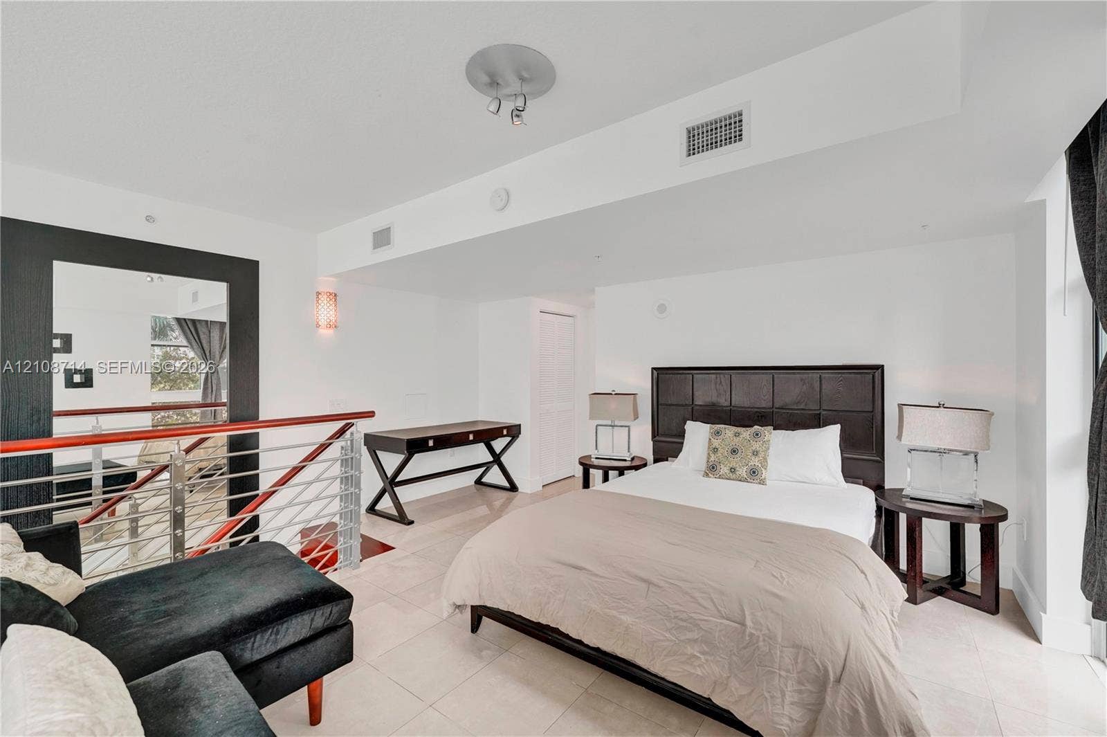 41 SE 5th Street, #317, Miami, Miami, FL 33131 Open-plan interior featuring large-format tile flooring, metal cable railing with a wood-finish handrail, and recessed ceiling lighting