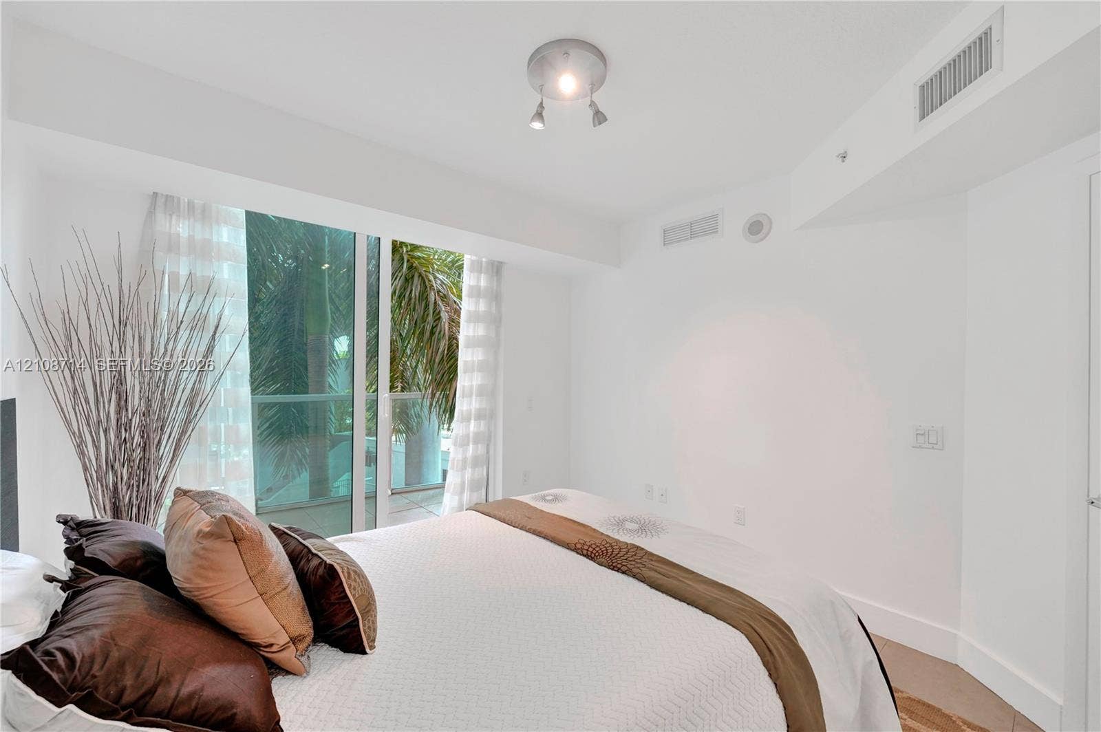 41 SE 5th Street, #317, Miami, Miami, FL 33131 Floor-to-ceiling glass sliding doors opening to a balcony with palm tree scenery and polished multi-directional track lighting
