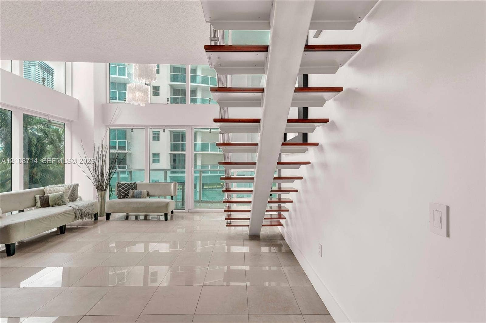 41 SE 5th Street, #317, Miami, Miami, FL 33131 Floating staircase featuring wood treads and white stringers, floor-to-ceiling windows, and tile flooring
