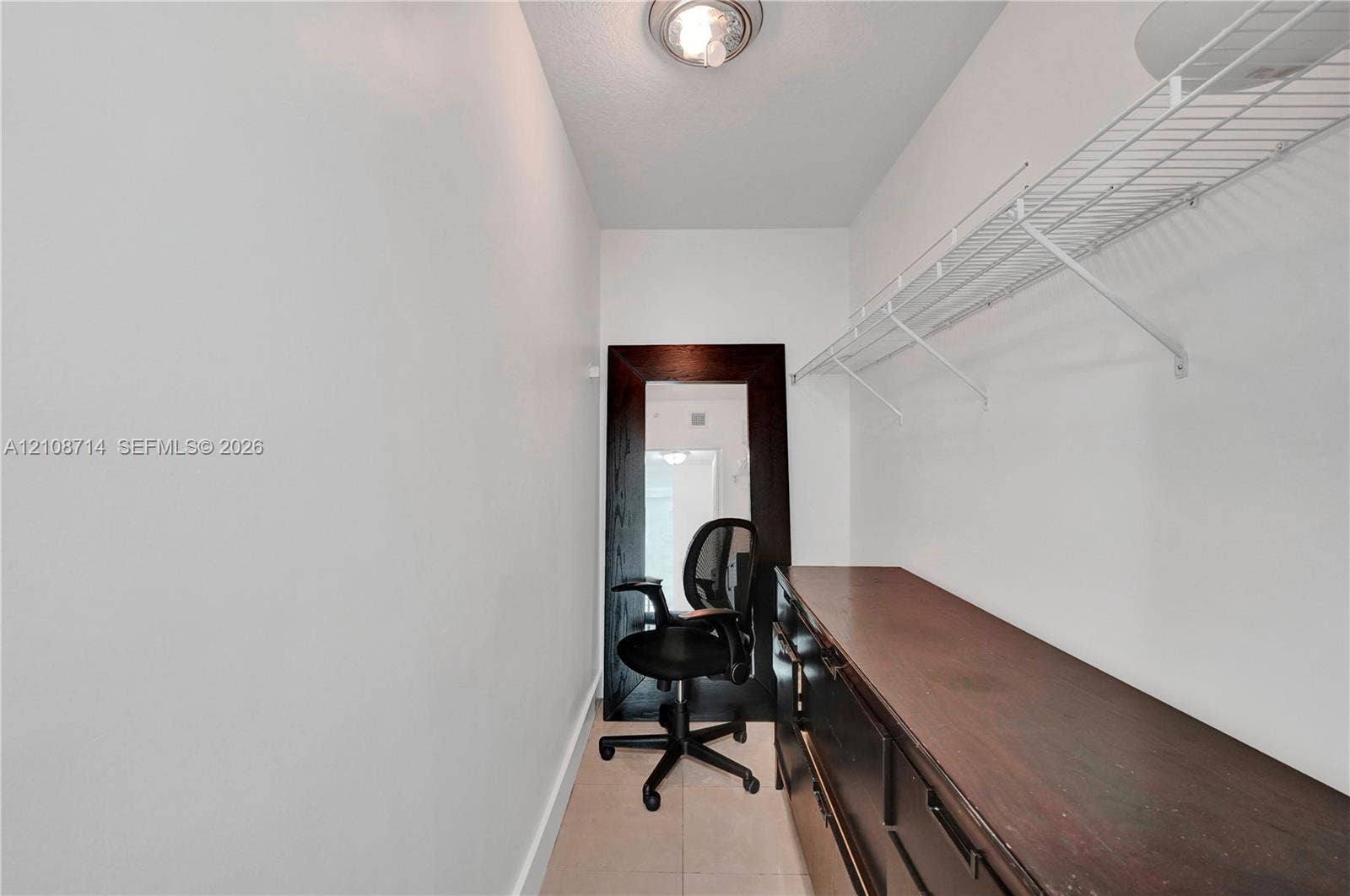 41 SE 5th Street, #317, Miami, Miami, FL 33131 Storage space featuring tile flooring, white walls, overhead lighting, wire shelving, and dark wood-finish cabinetry