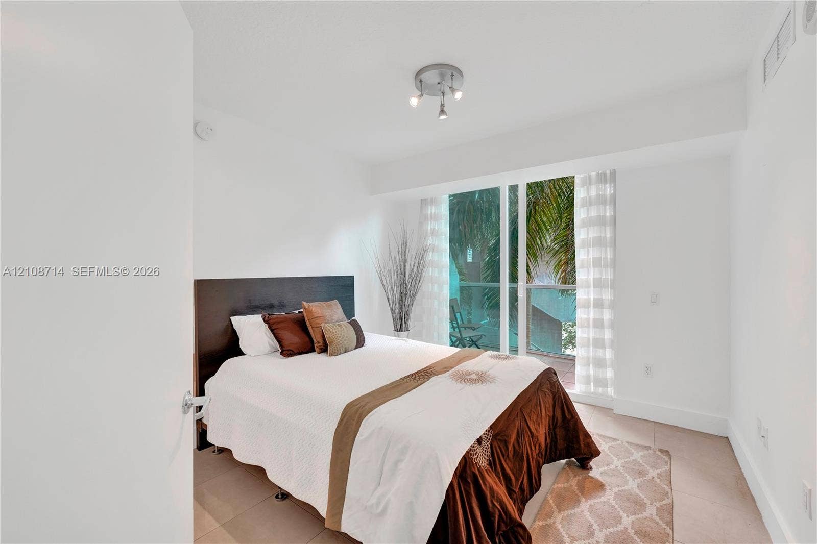 41 SE 5th Street, #317, Miami, Miami, FL 33131 Floor-to-ceiling glass sliding doors, neutral tile flooring, and multi-directional ceiling-mounted lighting