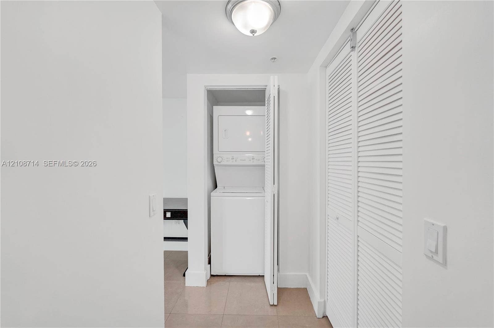 41 SE 5th Street, #317, Miami, Miami, FL 33131 Stacked laundry unit, louvered closet doors, and flush-mount overhead lighting