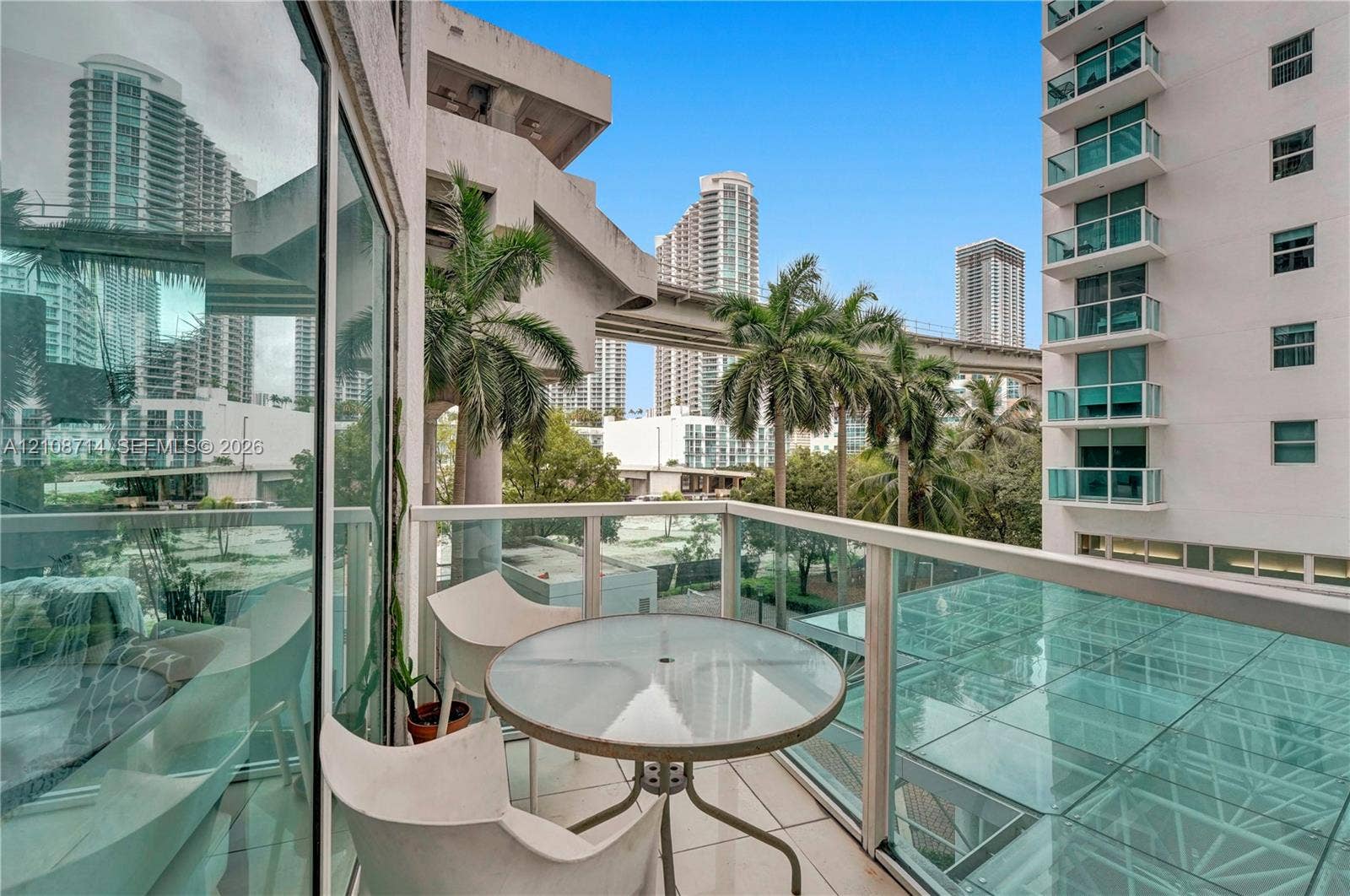 41 SE 5th Street, #317, Miami, Miami, FL 33131 Private balcony featuring glass-panel railings, light-toned floor tile, and floor-to-ceiling glass wall