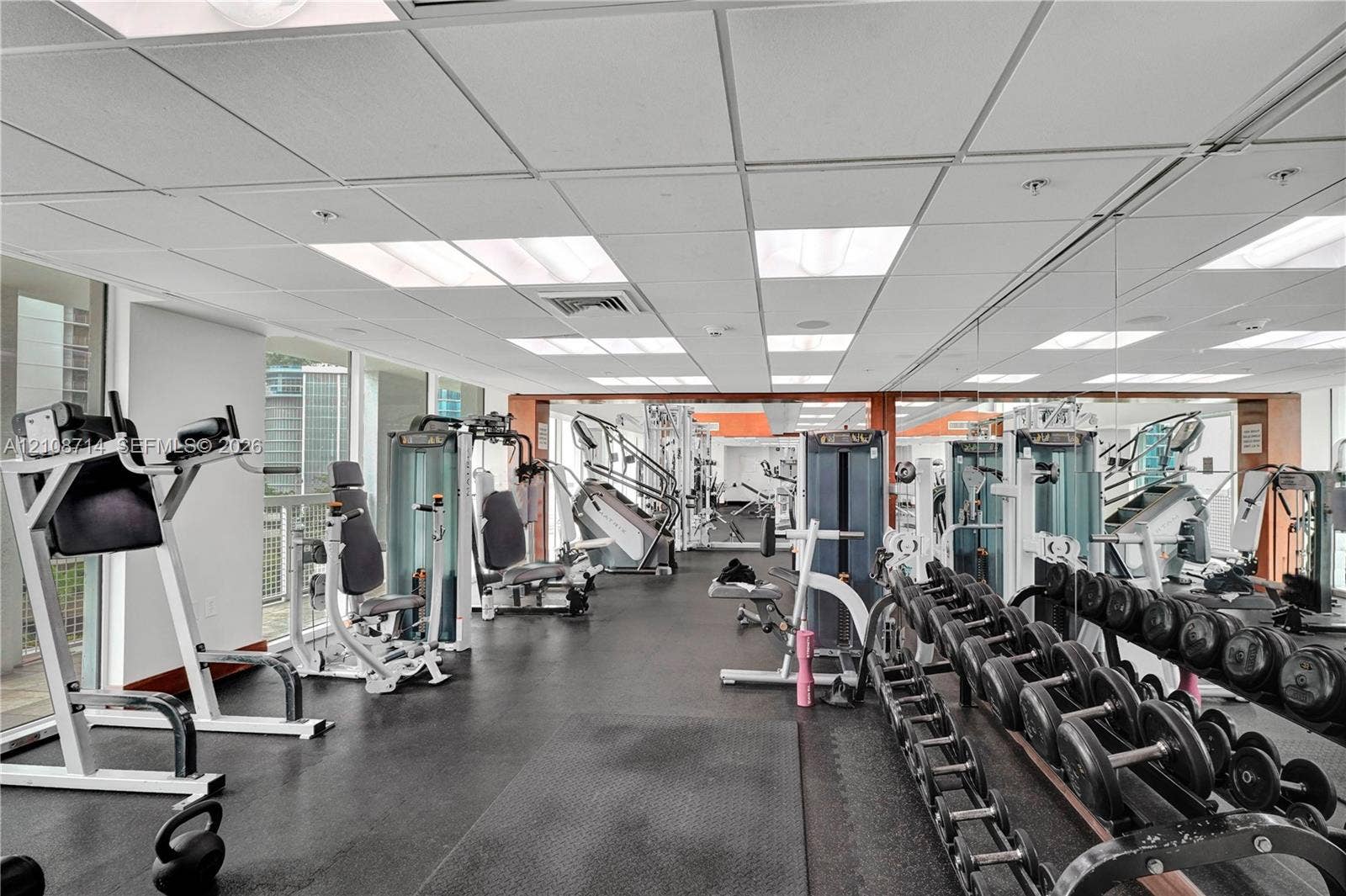 41 SE 5th Street, #317, Miami, Miami, FL 33131 Fitness facility featuring rubberized flooring, expansive wall-to-wall mirrors, and a suspended drop ceiling with recessed lighting