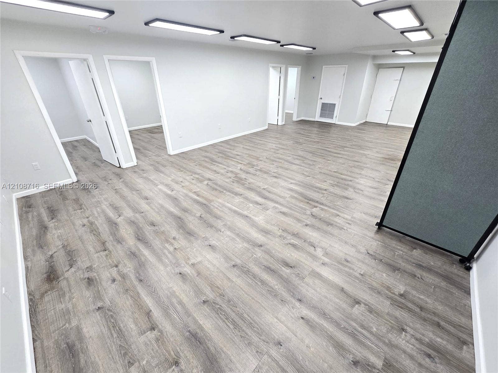Open-concept interior featuring wood-finish flooring, neutral walls, and recessed panel lighting