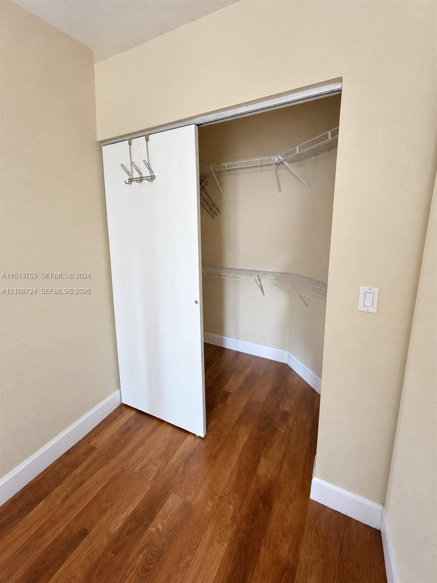 972 NW 92nd Terrace, Plantation, Plantation, FL 33324 Walk-in closet featuring wood-finish flooring, white sliding door, and multi-tier wire shelving