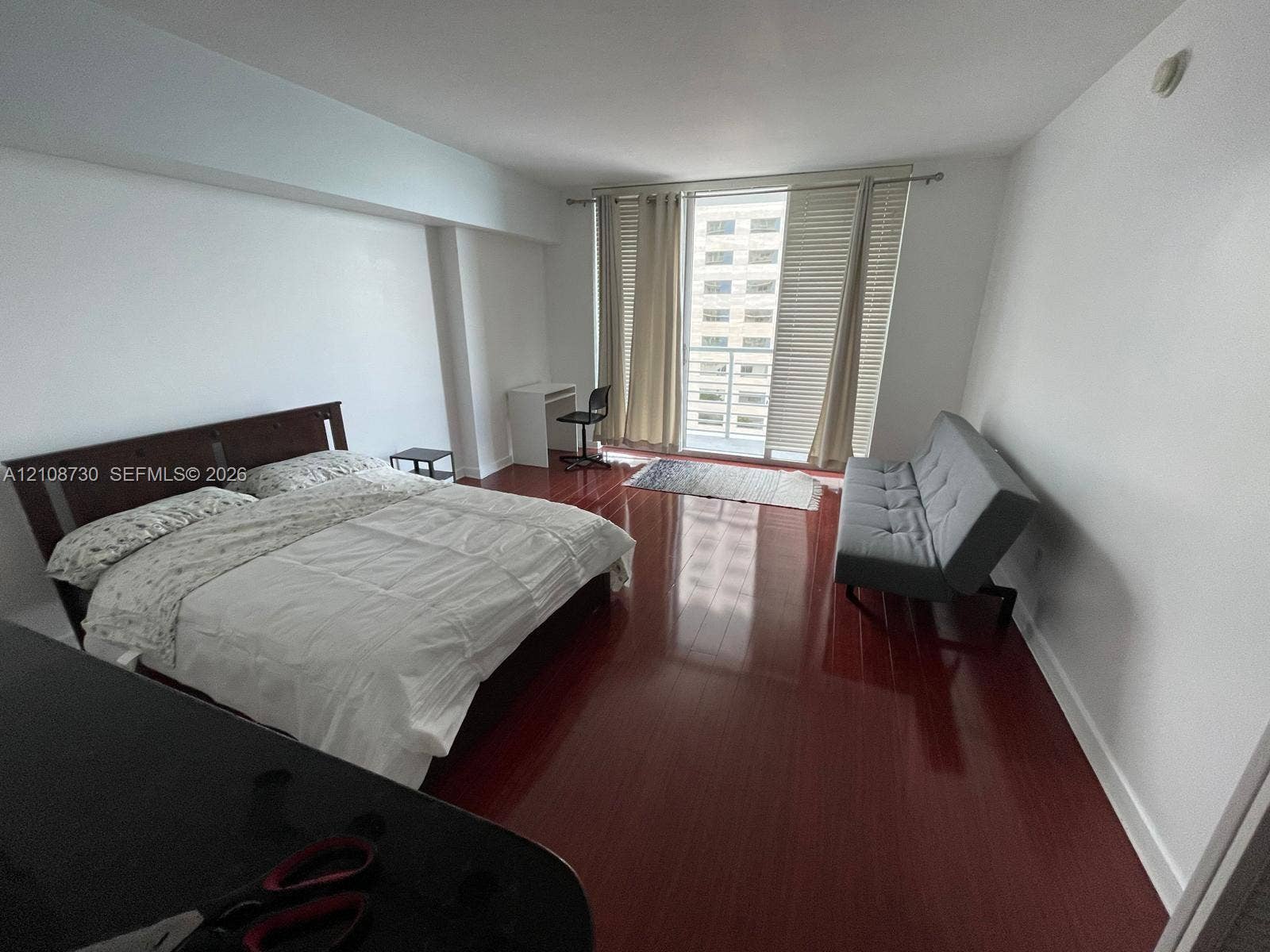 Miami, Miami, FL 33131 Spacious interior room featuring polished wood-finish flooring, crisp white walls, and a glass-paned door opening to a balcony