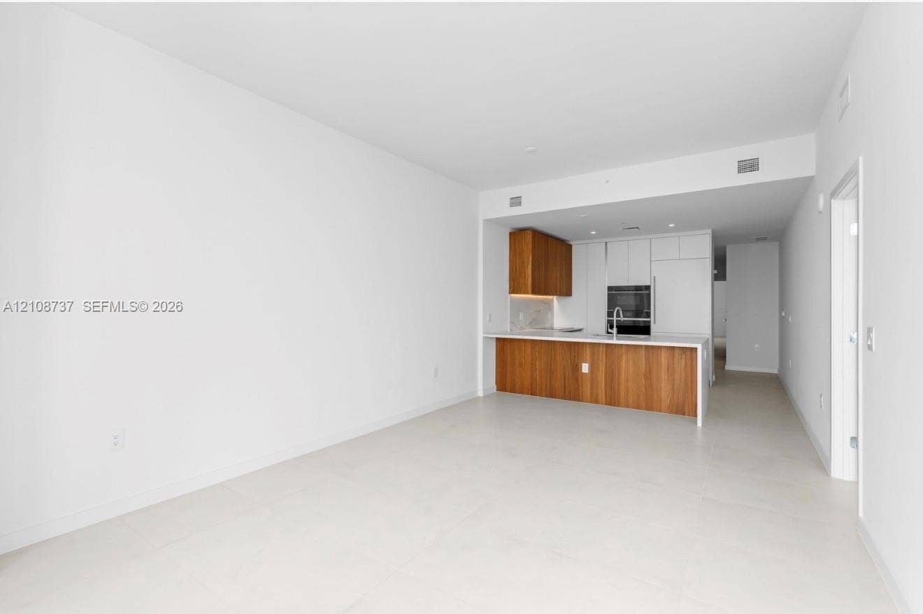 1400 Biscayne Boulevard, #3503, Miami, Miami, FL 33132 Kitchen featuring two-tone cabinetry, wood-finish lower cabinets, integrated wall oven, and light-toned tile flooring