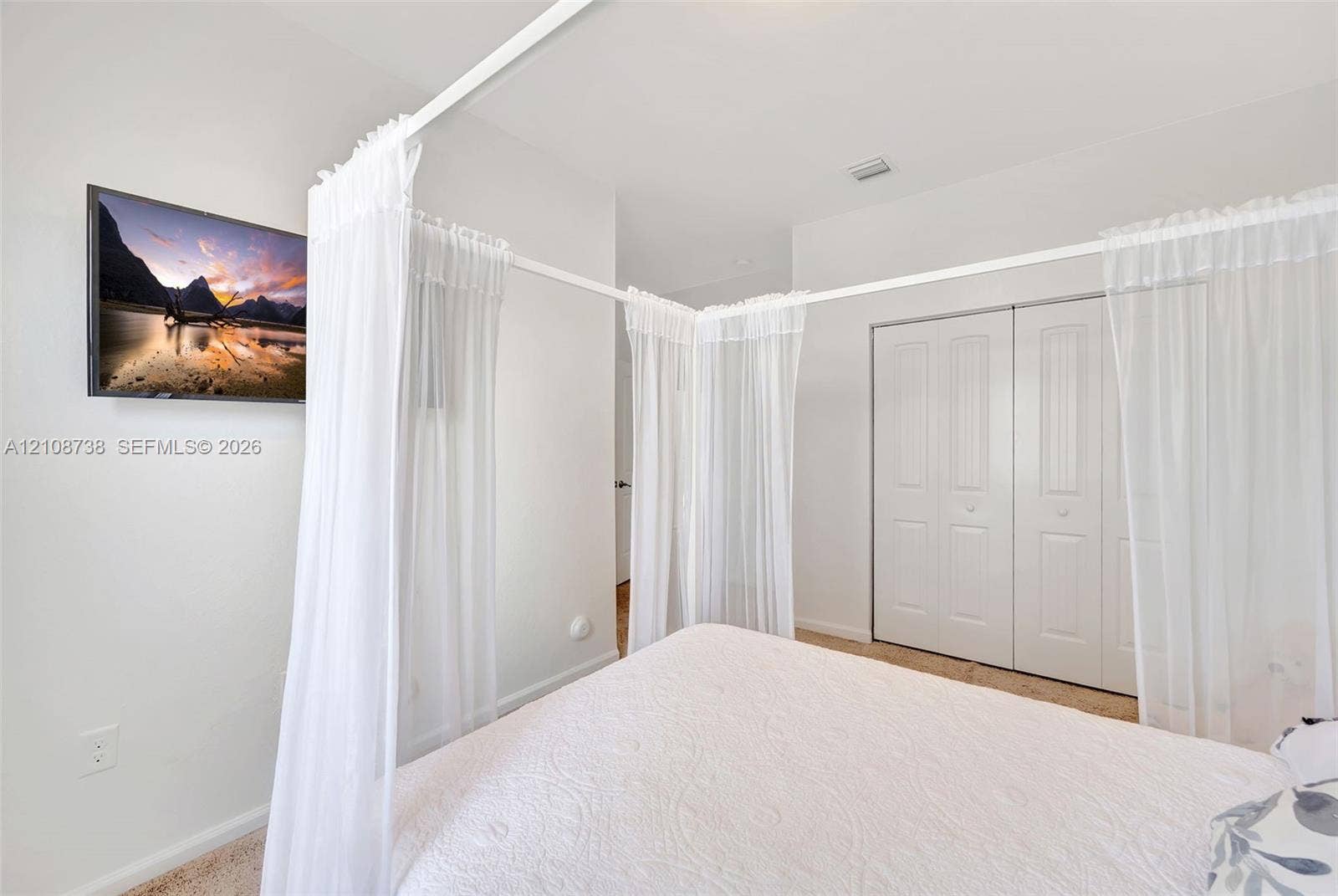 Neutral wall-to-wall carpeting, white interior paint, and sliding double-panel closet doors