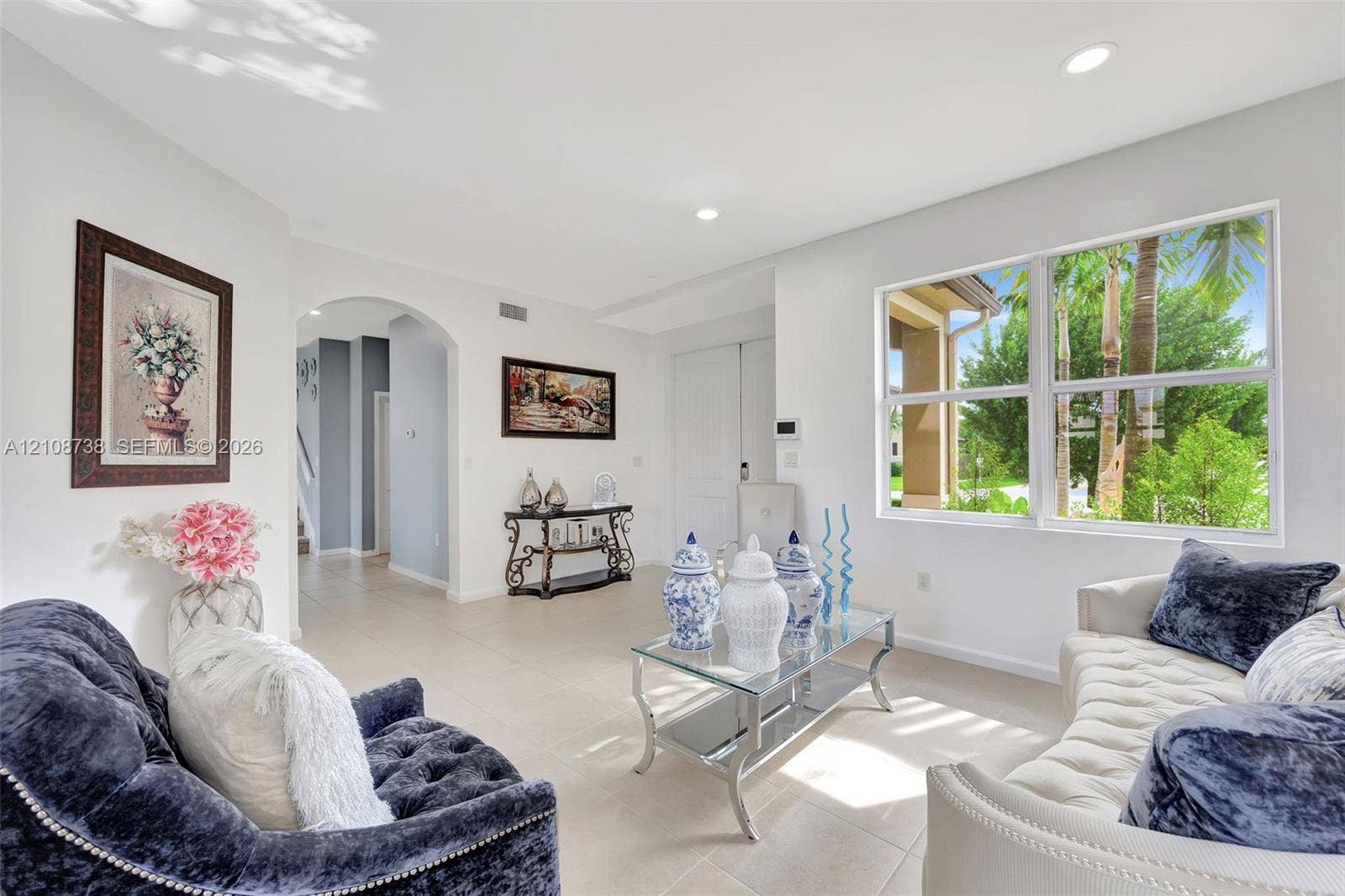 Neutral-toned tile flooring, recessed ceiling lighting, and a large multi-pane window
