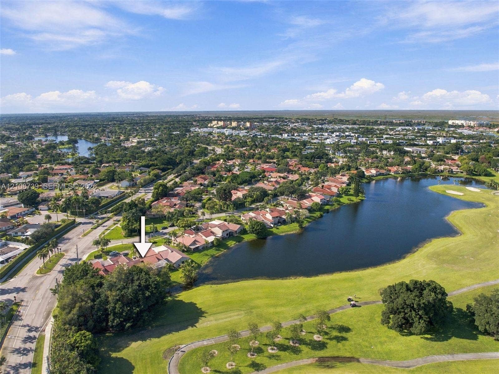 632 Village Lake Drive, Weston, FL 33326 Waterfront estate lot featuring a pristine lake with natural shoreline, manicured lawn grounds with mature landscaping, and prime lakeside positioning within an established residential community