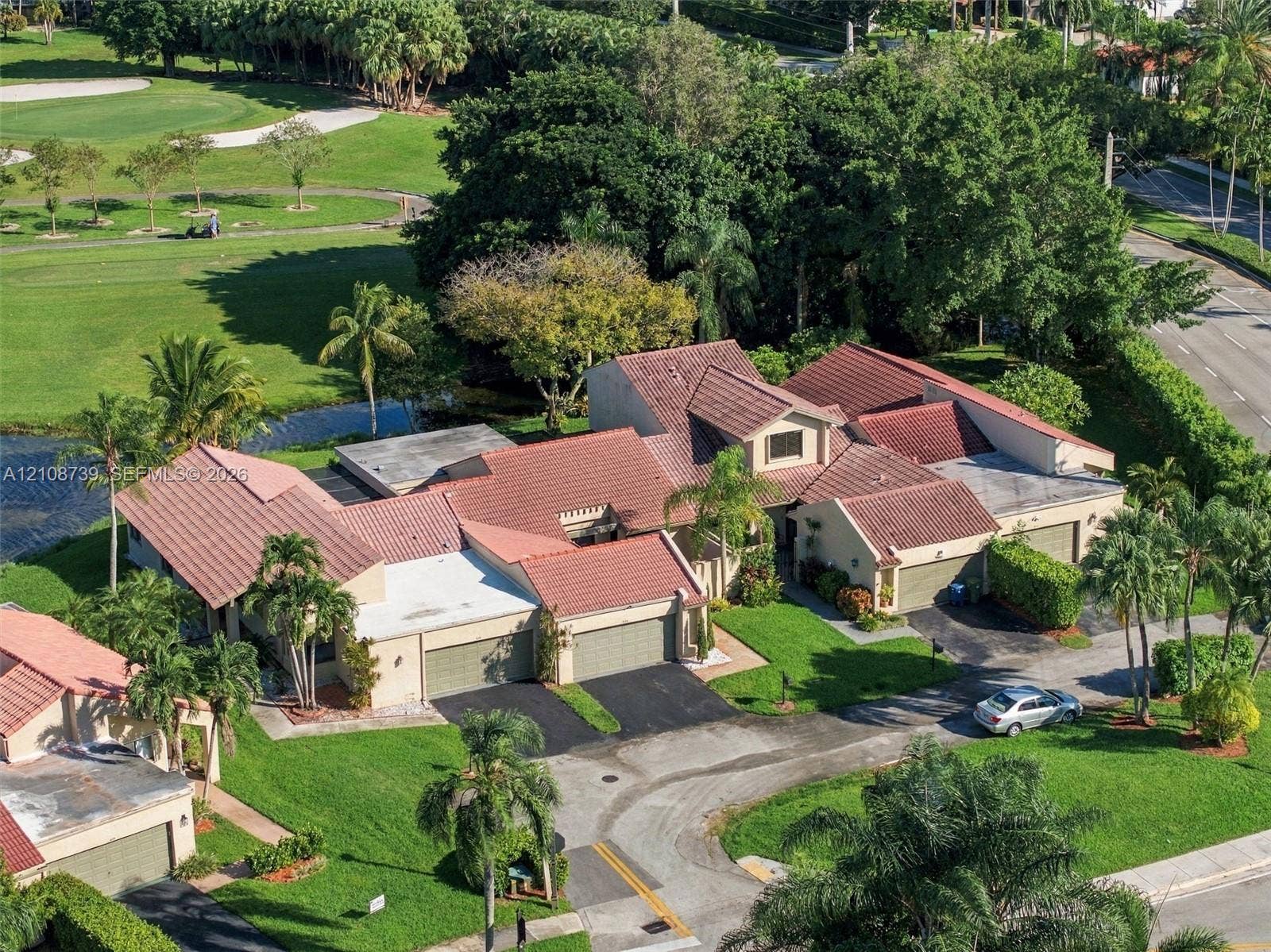 632 Village Lake Drive, Weston, FL 33326 Multi-structure residential property featuring terracotta-style roofing, stucco exterior, dual attached garages, and expansive manicured grounds with mature tropical landscaping