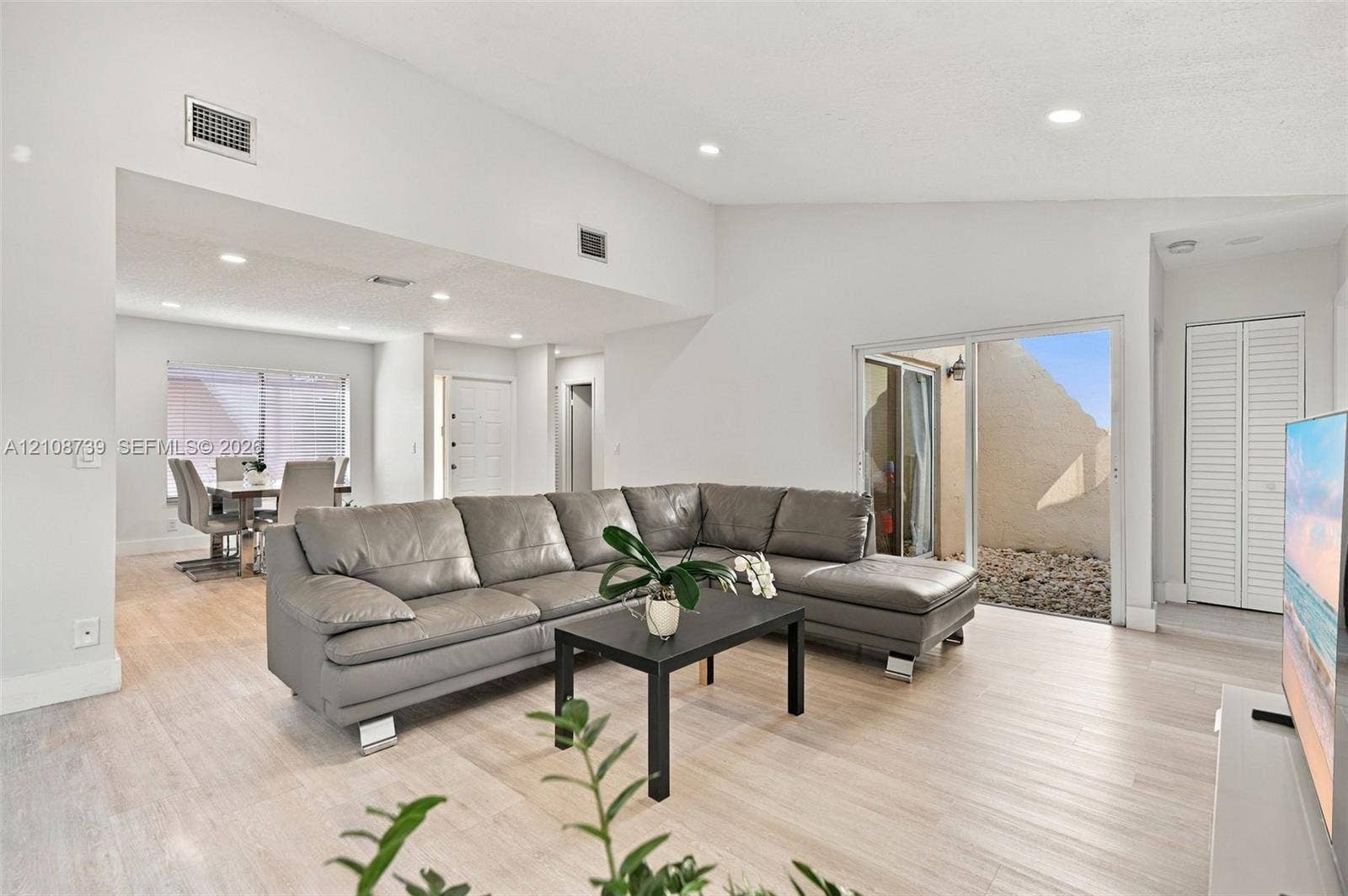 632 Village Lake Drive, Weston, FL 33326 Vaulted ceilings, light-tone wood-finish flooring, recessed lighting, and a sliding glass door providing external access
