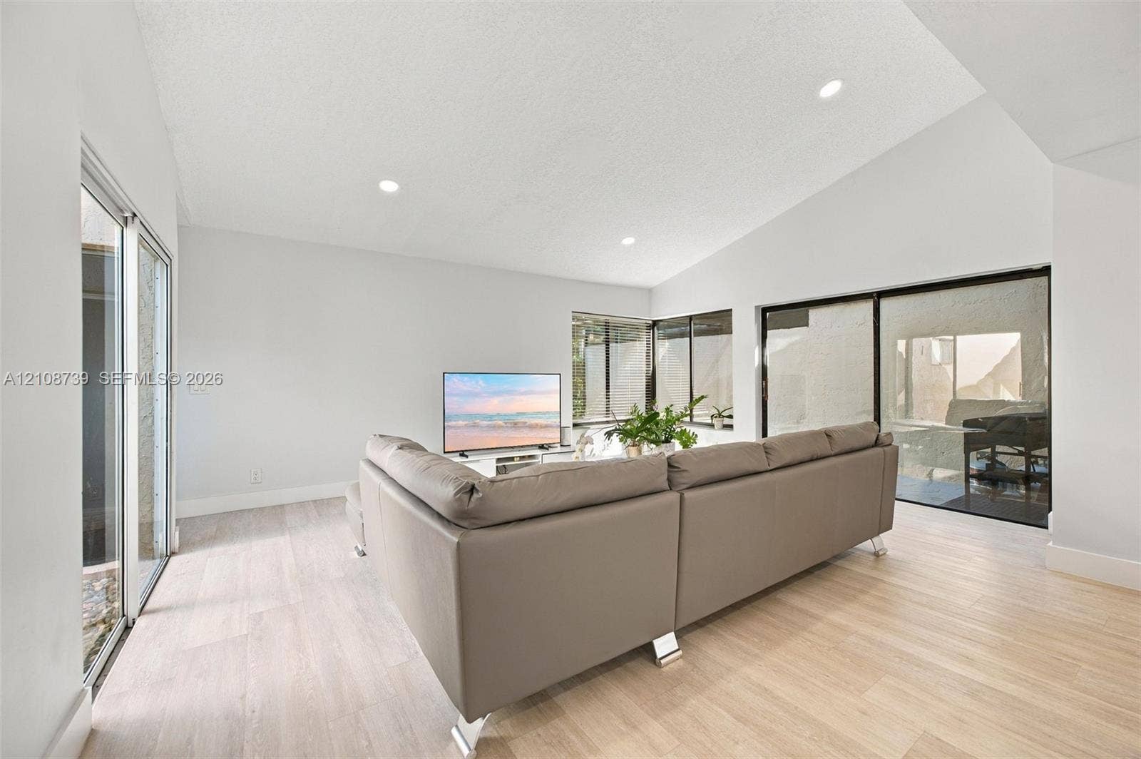 632 Village Lake Drive, Weston, FL 33326 Vaulted ceilings, wood-finish flooring, recessed lighting, and multiple sliding glass doors