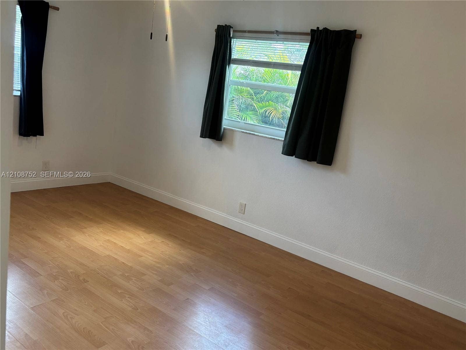 Interior space featuring wood-finish flooring, white walls, and dual windows