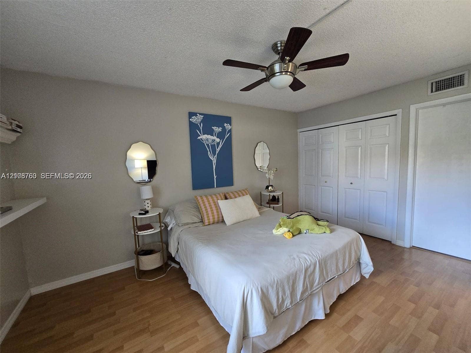 140 Lakeview Drive, #111, Weston, Weston, FL 33326 Wood-finish flooring, brushed metal ceiling fan with integrated lighting, and multi-panel sliding closet doors