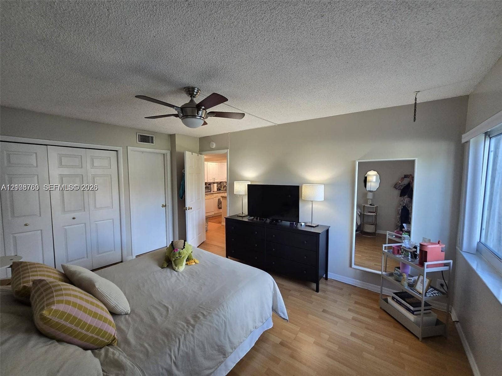 140 Lakeview Drive, #111, Weston, Weston, FL 33326 Room featuring wood-finish flooring, a ceiling fan with integrated lighting, and white multi-panel closet doors