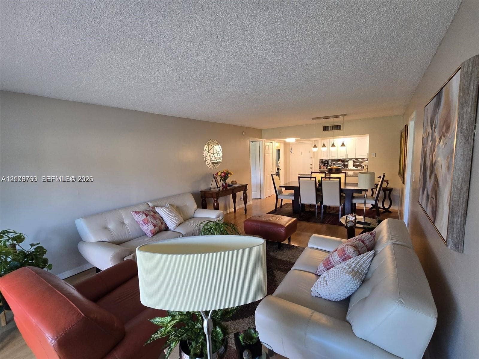 140 Lakeview Drive, #111, Weston, Weston, FL 33326 Living area featuring wood-finish flooring and recessed lighting with a galley-style kitchen including white cabinetry and tiled backsplash