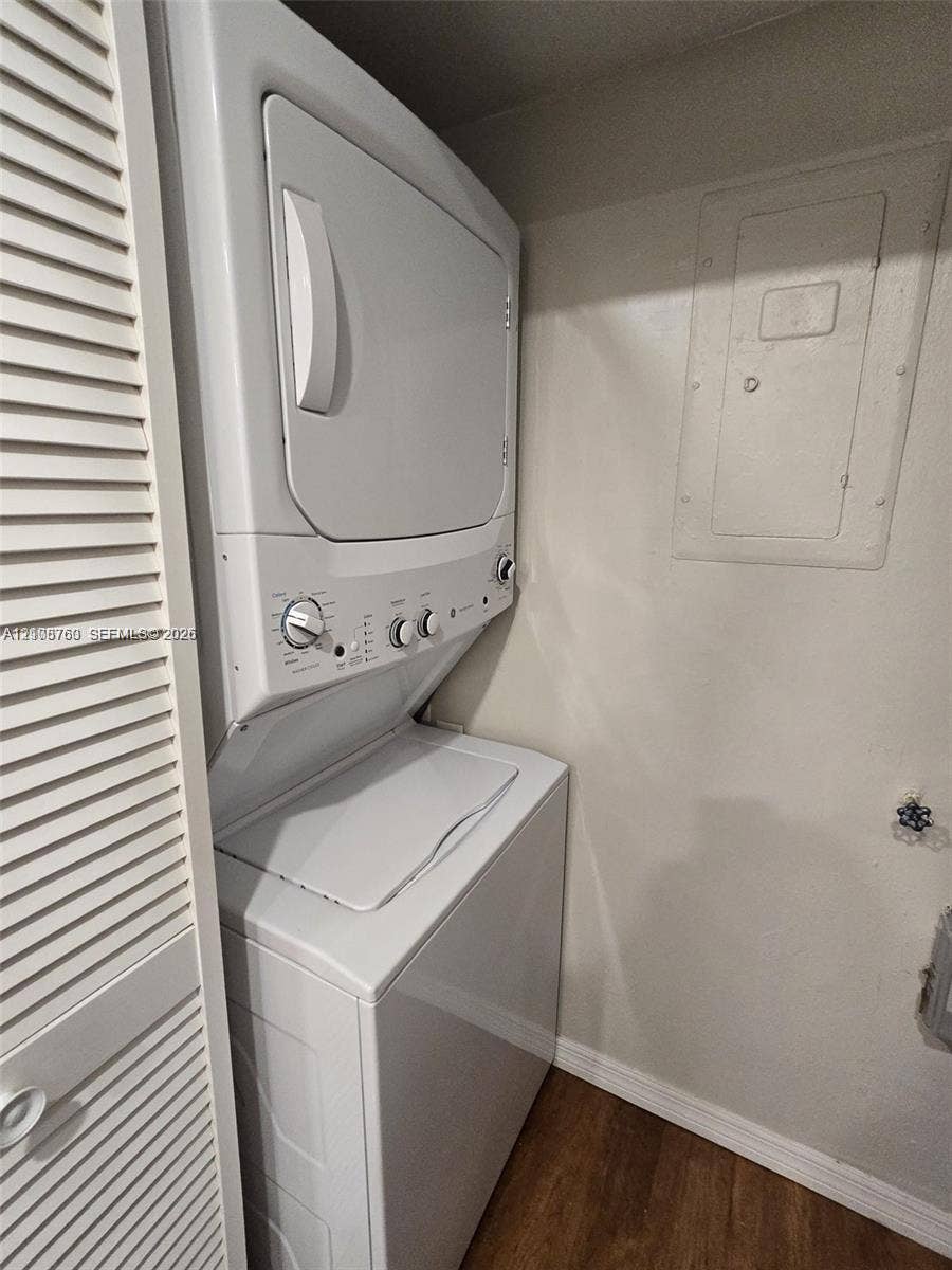 140 Lakeview Drive, #111, Weston, Weston, FL 33326 Stacked laundry appliance with white finish, housed within a closet featuring louvered doors and wood-finish flooring