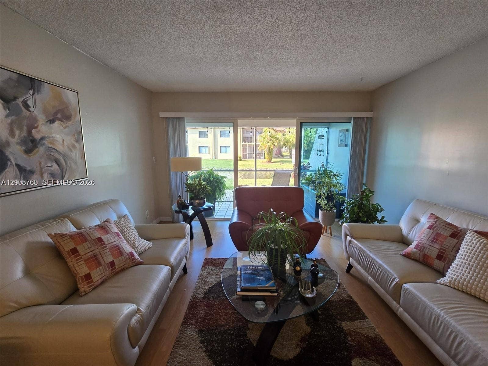 140 Lakeview Drive, #111, Weston, Weston, FL 33326 Living area featuring wood-finish flooring and large sliding glass doors leading to a screened balcony