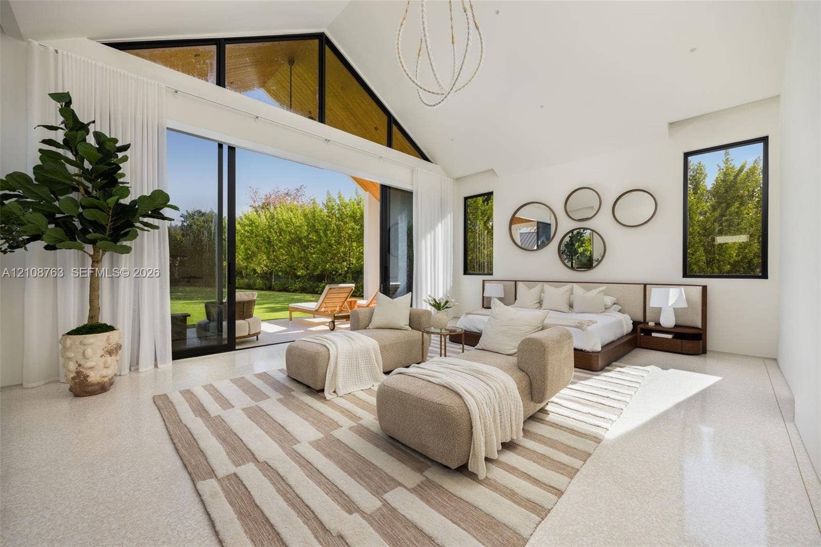 Vaulted ceiling with expansive glass gables, polished concrete flooring, sliding glass walls, and custom built-in headboard