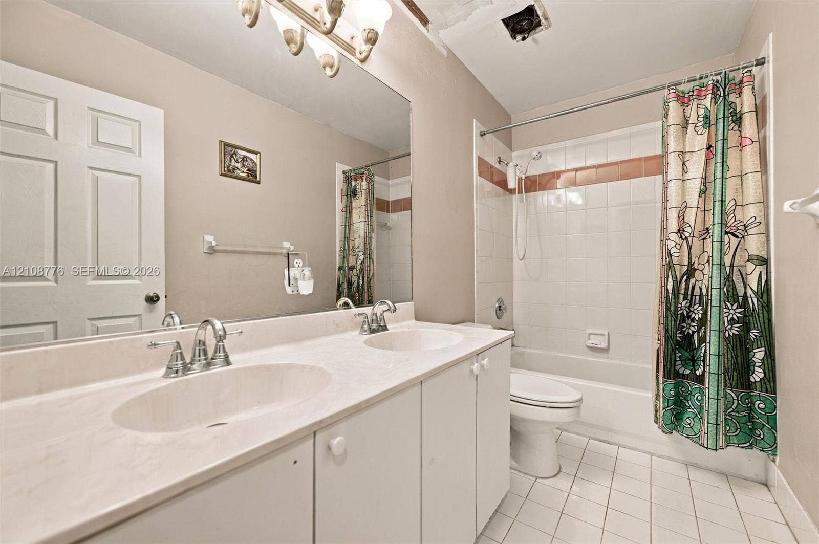 18041 SW 33rd Street, Miramar, FL 33029 Double vanity featuring integrated oval basins, expansive wall-to-wall mirror, white cabinetry, tile-surround shower and tub combination, and ceramic tile flooring