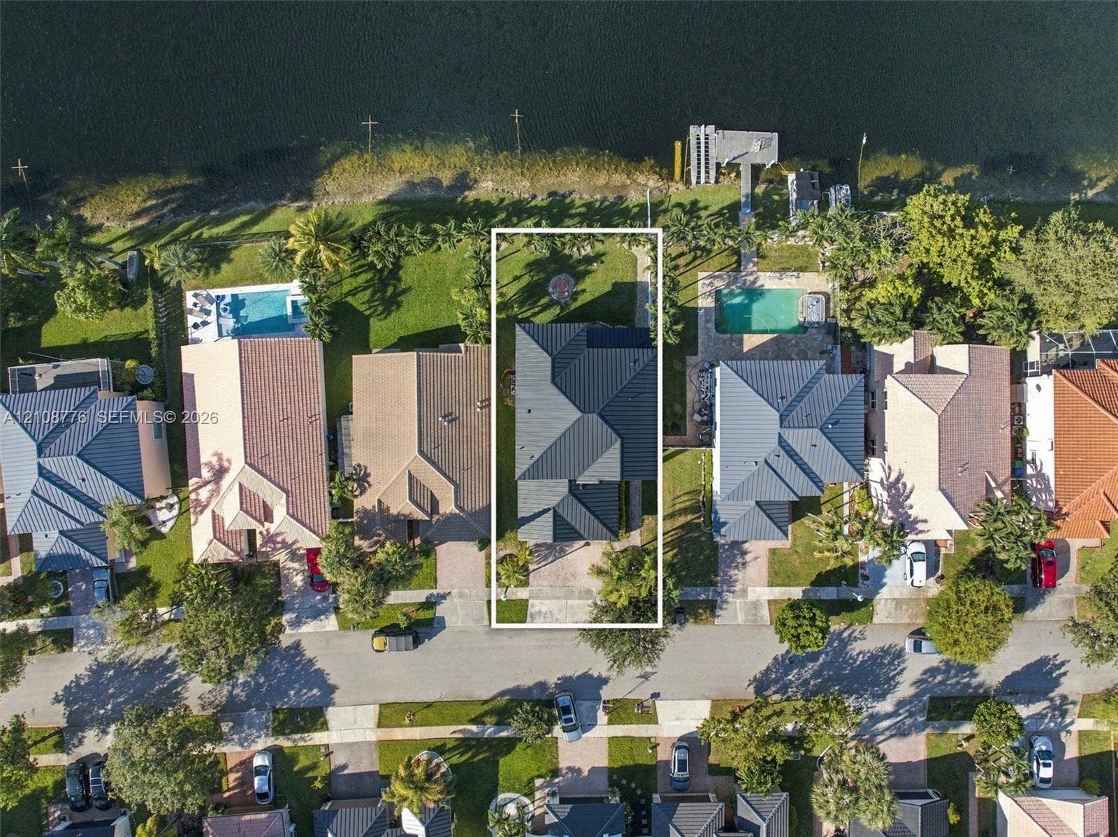 18041 SW 33rd Street, Miramar, FL 33029 Waterfront property featuring direct canal access, a private dock, and a multi-pitched roof