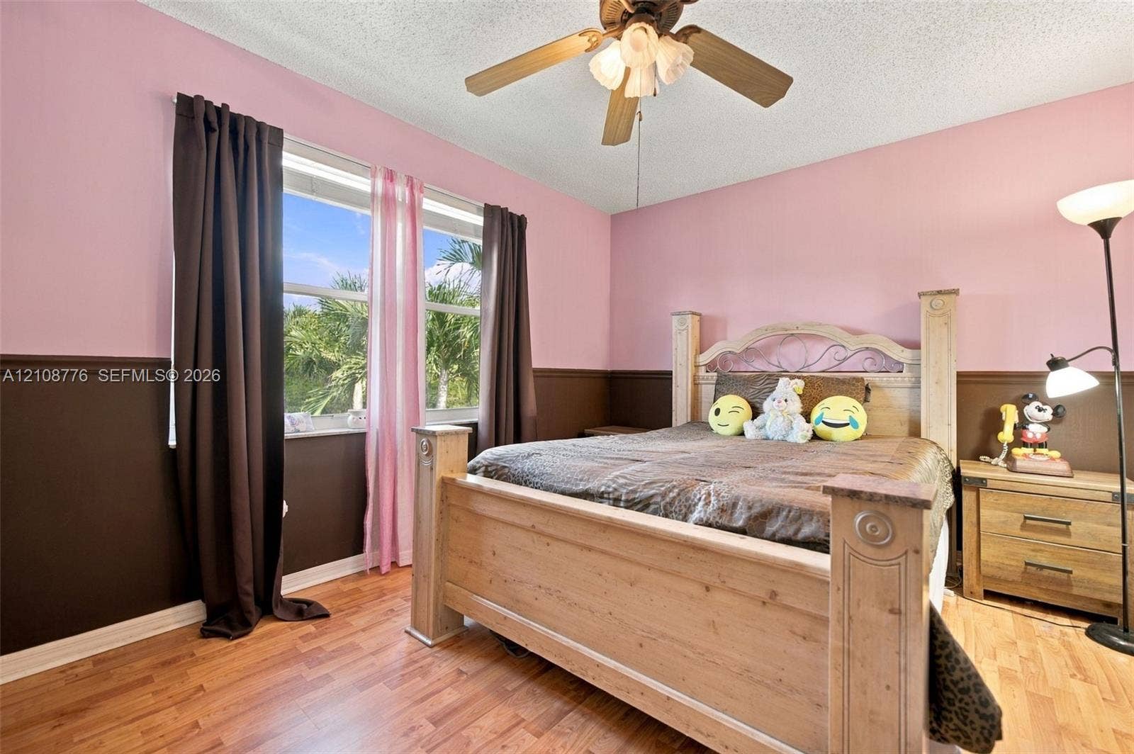 18041 SW 33rd Street, Miramar, FL 33029 Room featuring wood-finish flooring, two-tone wall paint with a chair rail, a ceiling fan with integrated light fixture, and a large window