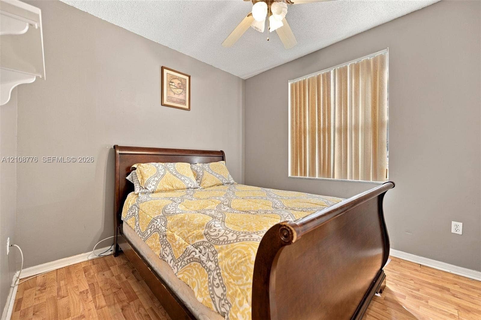 18041 SW 33rd Street, Miramar, FL 33029 Room featuring wood-finish flooring, a ceiling-mounted fan with integrated lighting, and a window with vertical blinds