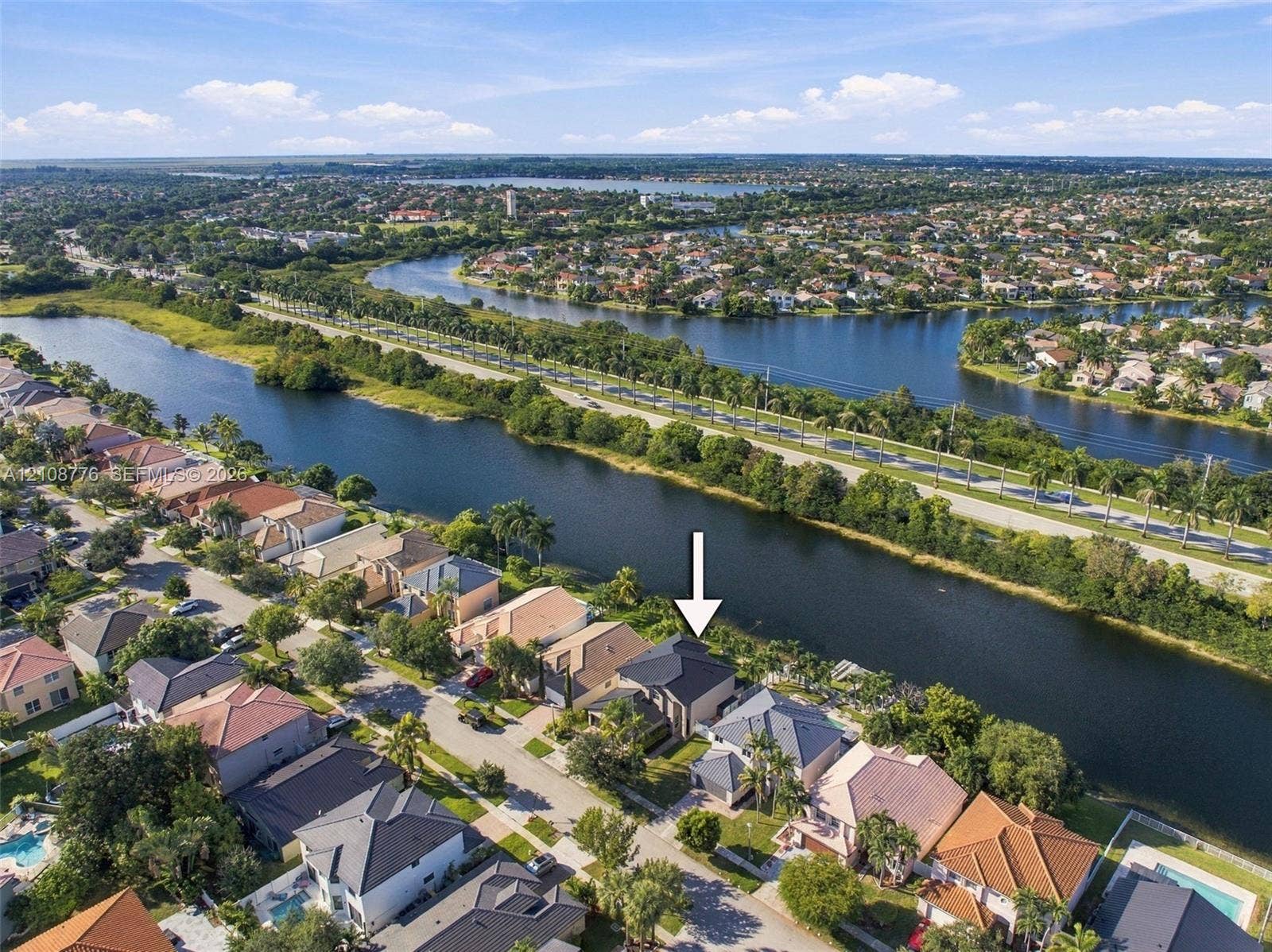 18041 SW 33rd Street, Miramar, FL 33029 Waterfront property featuring a canal-side position, multi-level architectural design, and a shingled roof