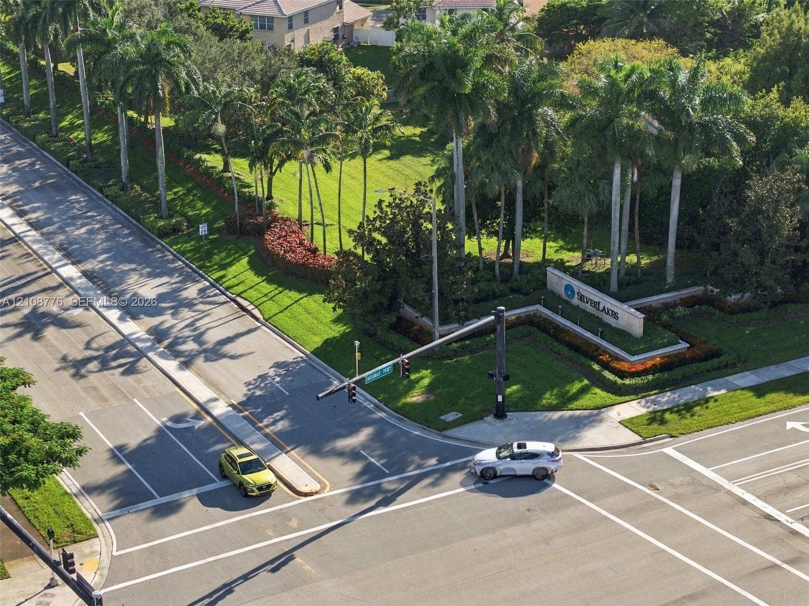18041 SW 33rd Street, Miramar, FL 33029 Community entrance featuring mature palm trees, landscaped green space, and prominent stone-finish signage