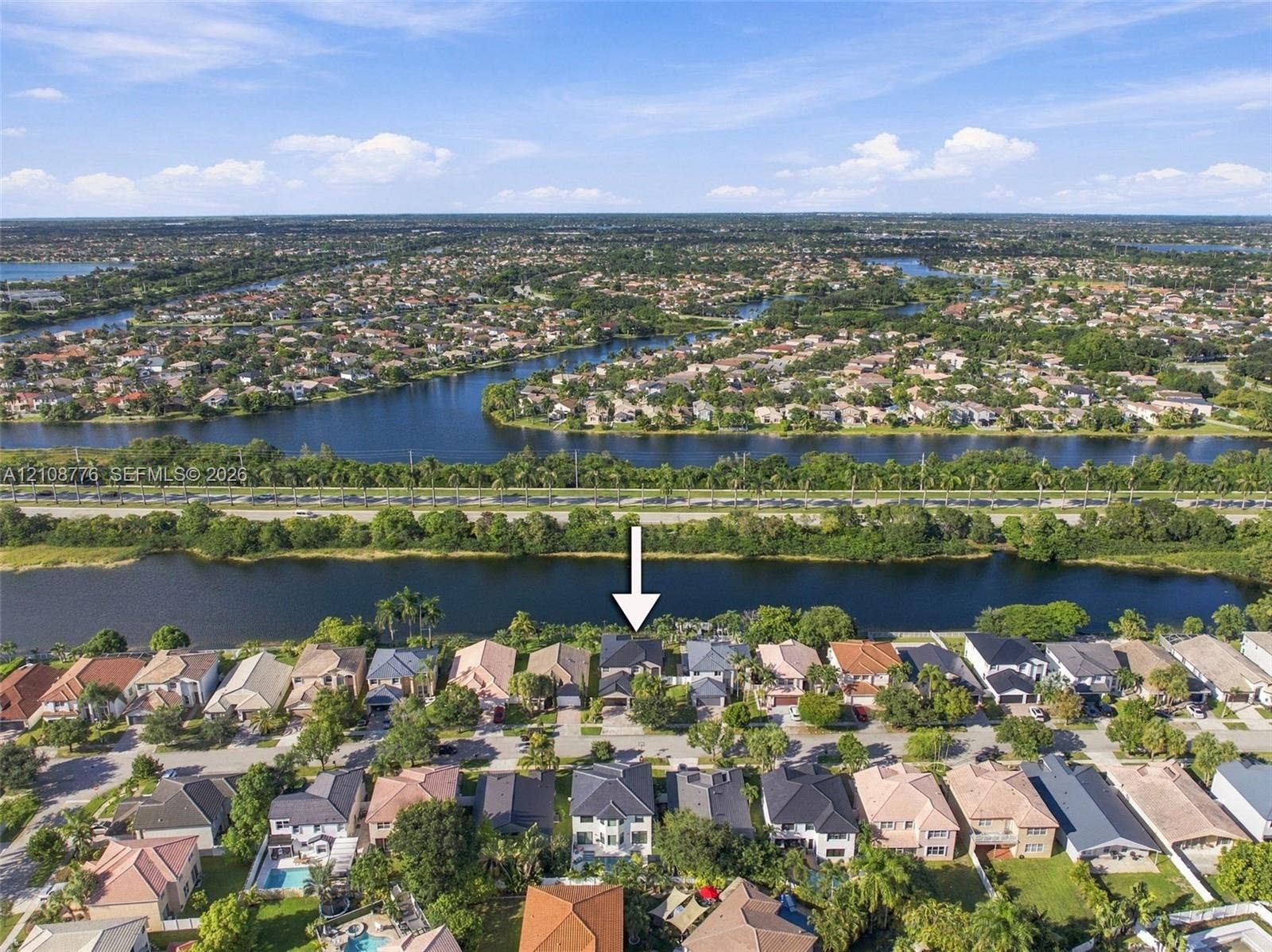 18041 SW 33rd Street, Miramar, FL 33029 Waterfront residential property featuring a multi-story layout, shingle roof, and direct access to a canal waterway