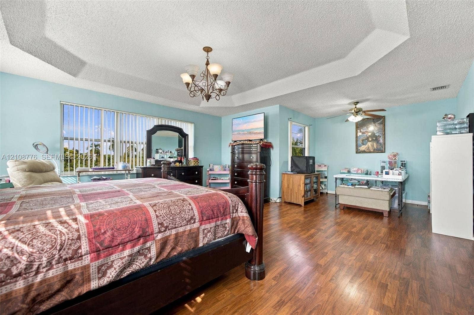 18041 SW 33rd Street, Miramar, FL 33029 Tray ceiling with recessed lighting, wood-finish flooring, multi-pane window with vertical blinds, and a central tiered chandelier