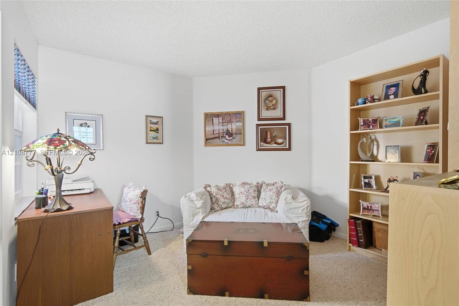 Room interior featuring neutral wall paint, carpeted flooring, and built-in wood shelving