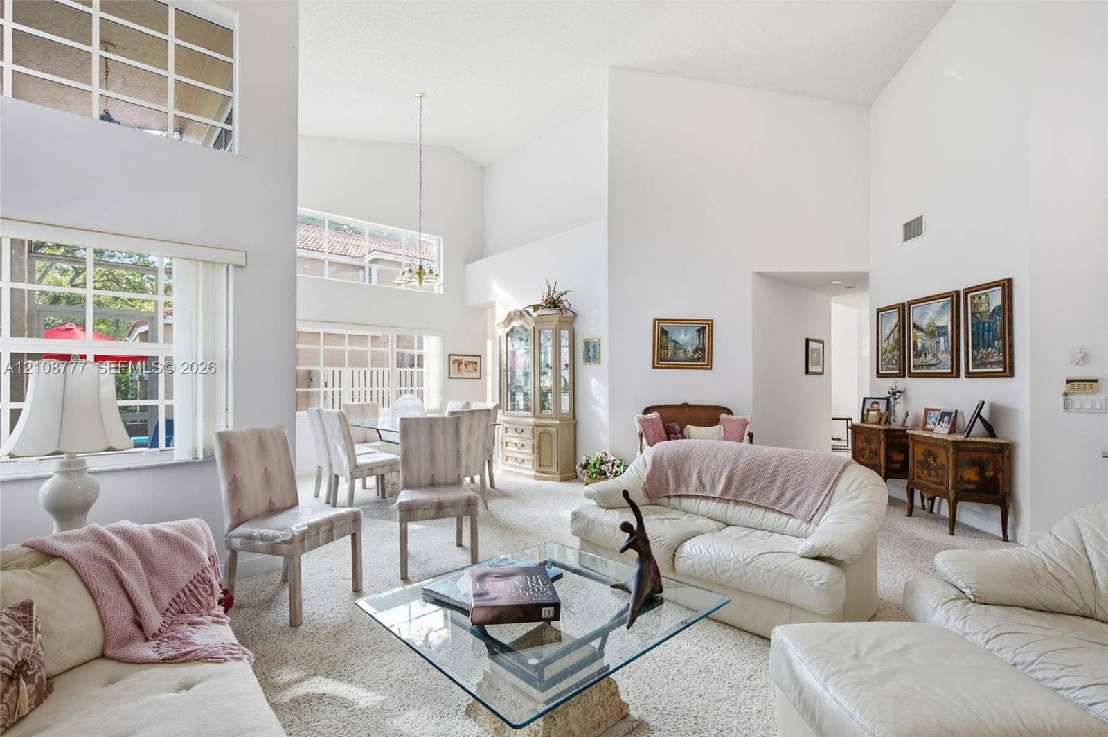 Vaulted ceilings, expansive multi-pane windows, and a suspended dining area light fixture