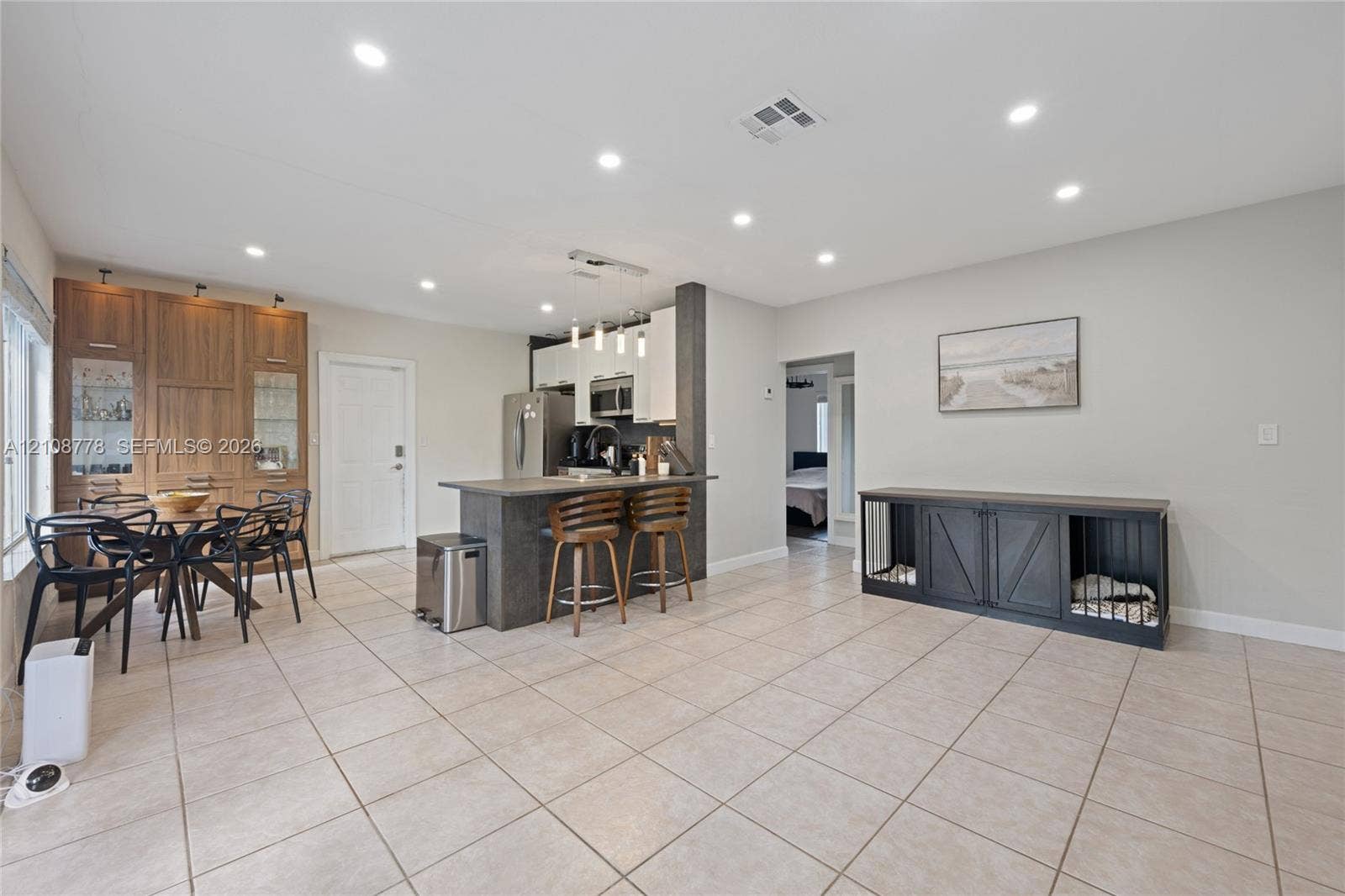3116 Hayes Street, Hollywood, FL 33021 Open-concept kitchen featuring a stone-toppe island with pendant lighting, integrated wood-finish cabinetry, recessed ceiling lights, and tile flooring throughout