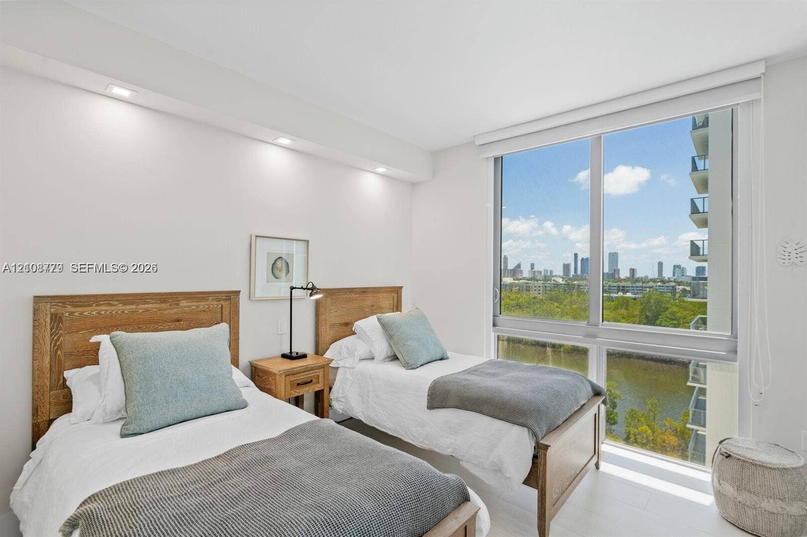 Floor-to-ceiling windows featuring urban and water scenery, recessed ceiling lighting, and smooth-finish flooring