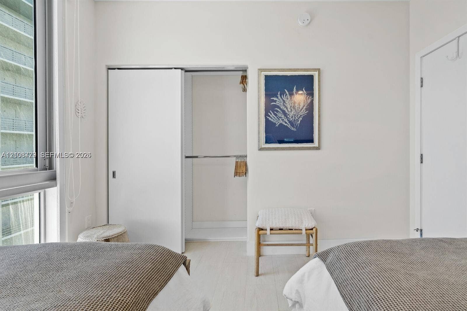 Floor-to-ceiling windows, light-toned hard-surface flooring, and sliding closet doors