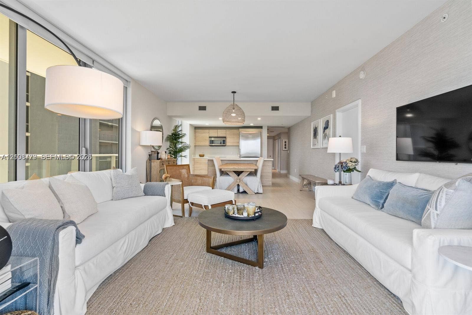 Floor-to-ceiling glass sliding doors, textured wall treatments, wood-finish flooring, and integrated kitchen cabinetry
