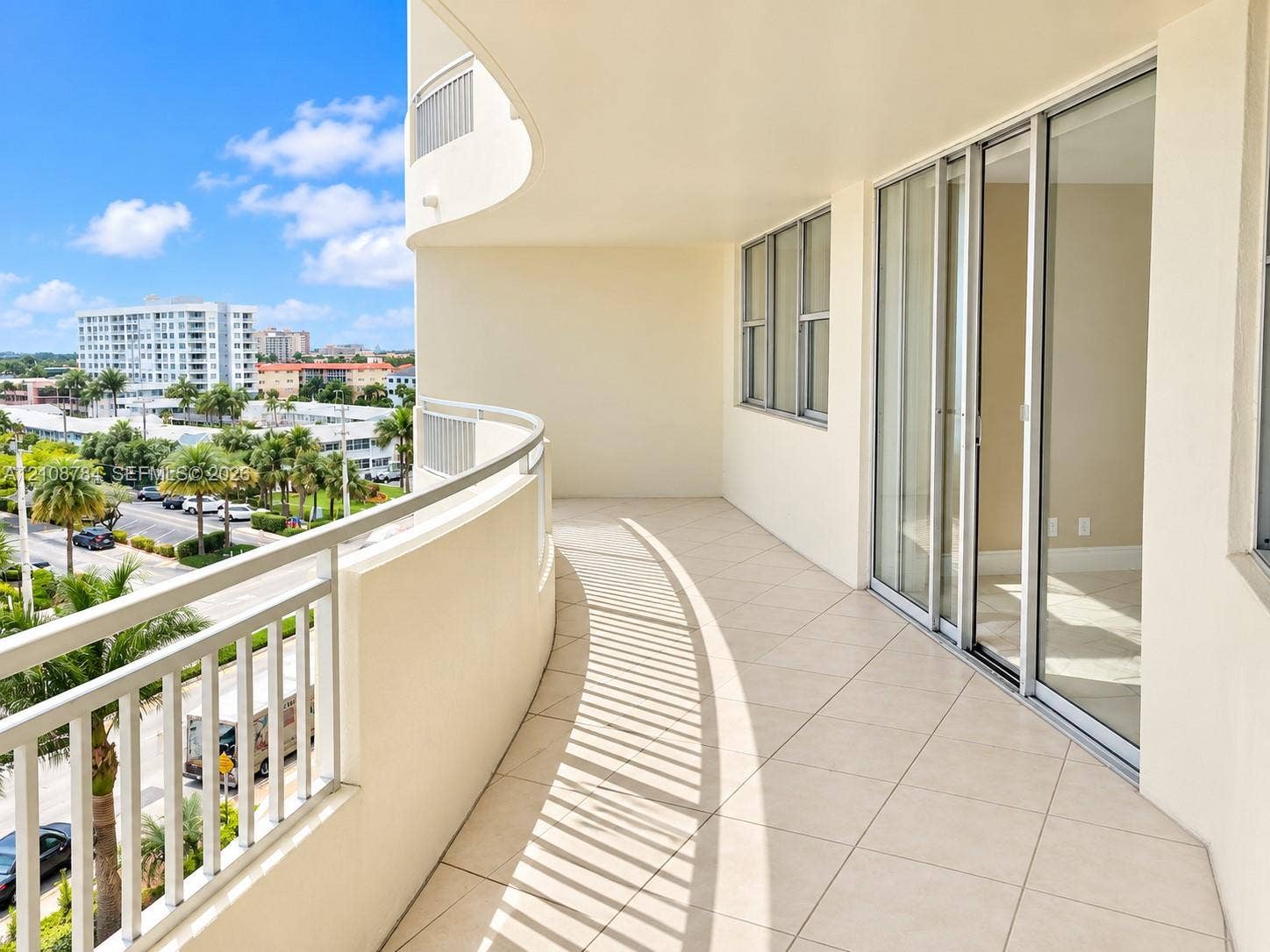 Curved balcony featuring tile flooring, aluminum railing, and floor-to-ceiling glass sliding doors
