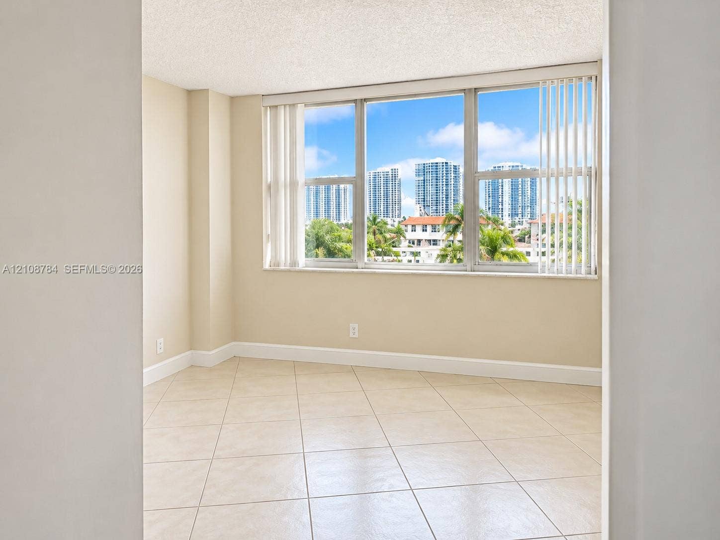 Large window with vertical blinds, tile flooring, and neutral wall tones