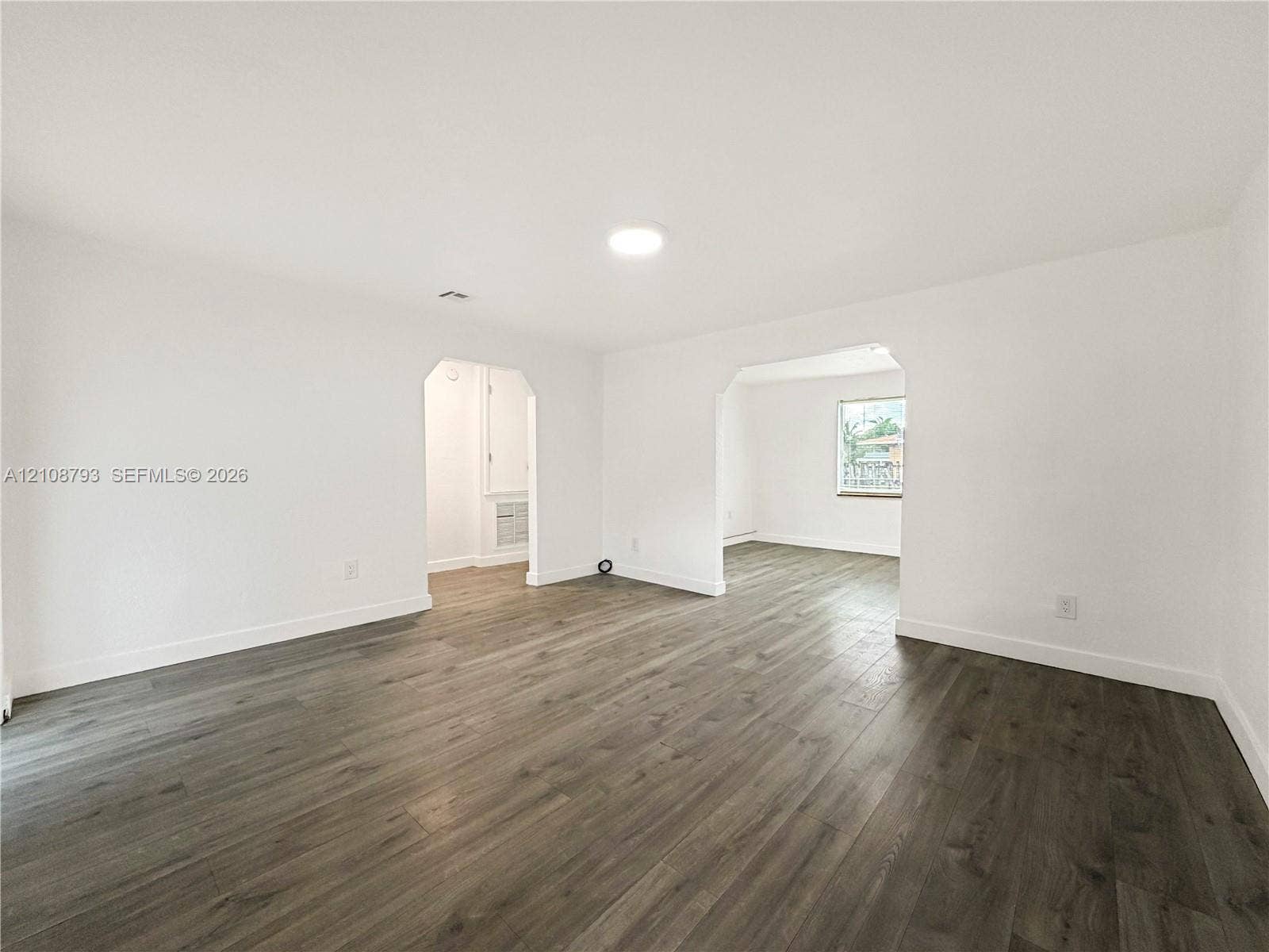 Interior space featuring wood-finish flooring, recessed ceiling lighting, and arched doorways