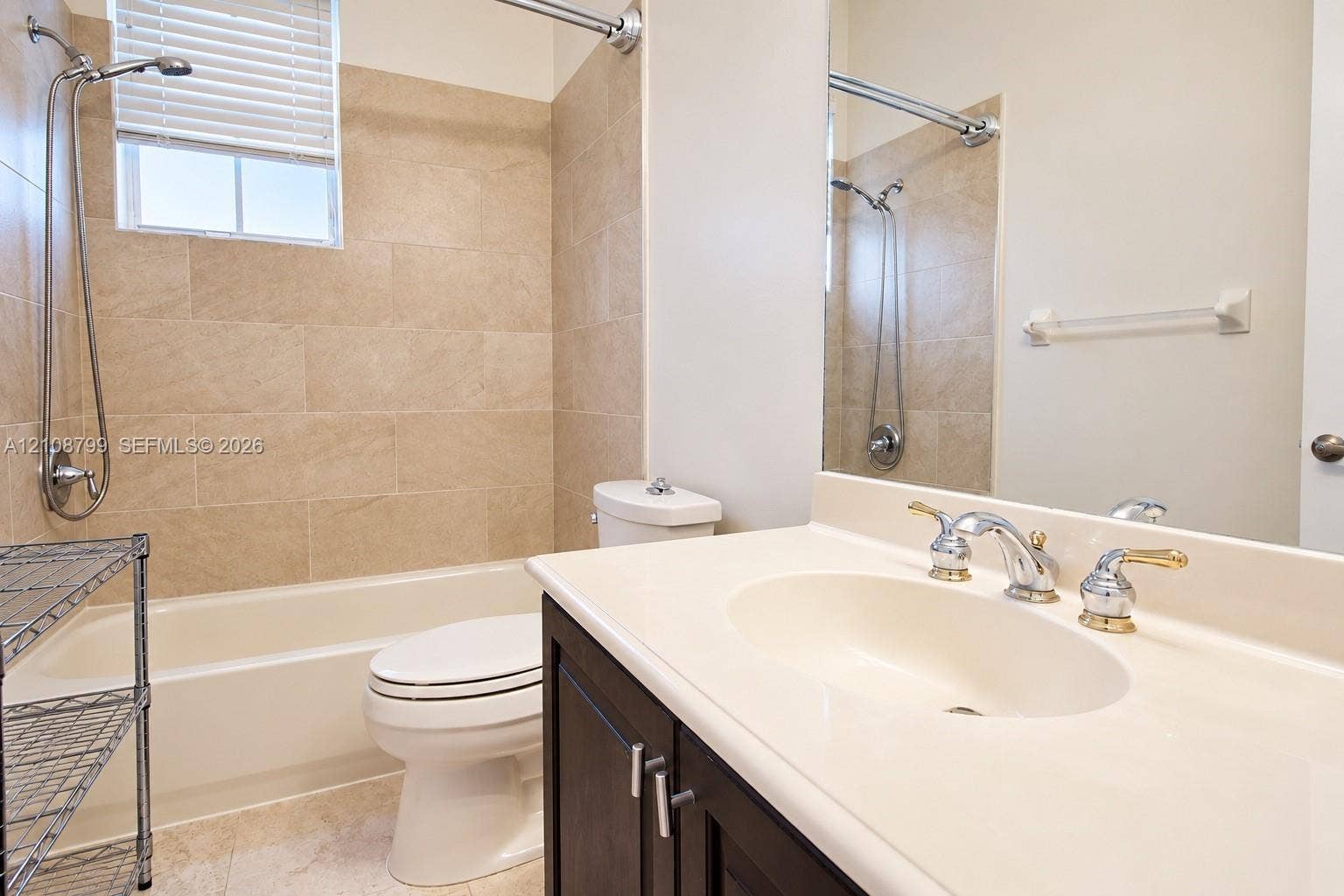 Bathroom featuring a vanity with a solid-surface countertop, integral sink, and dual-handle faucet