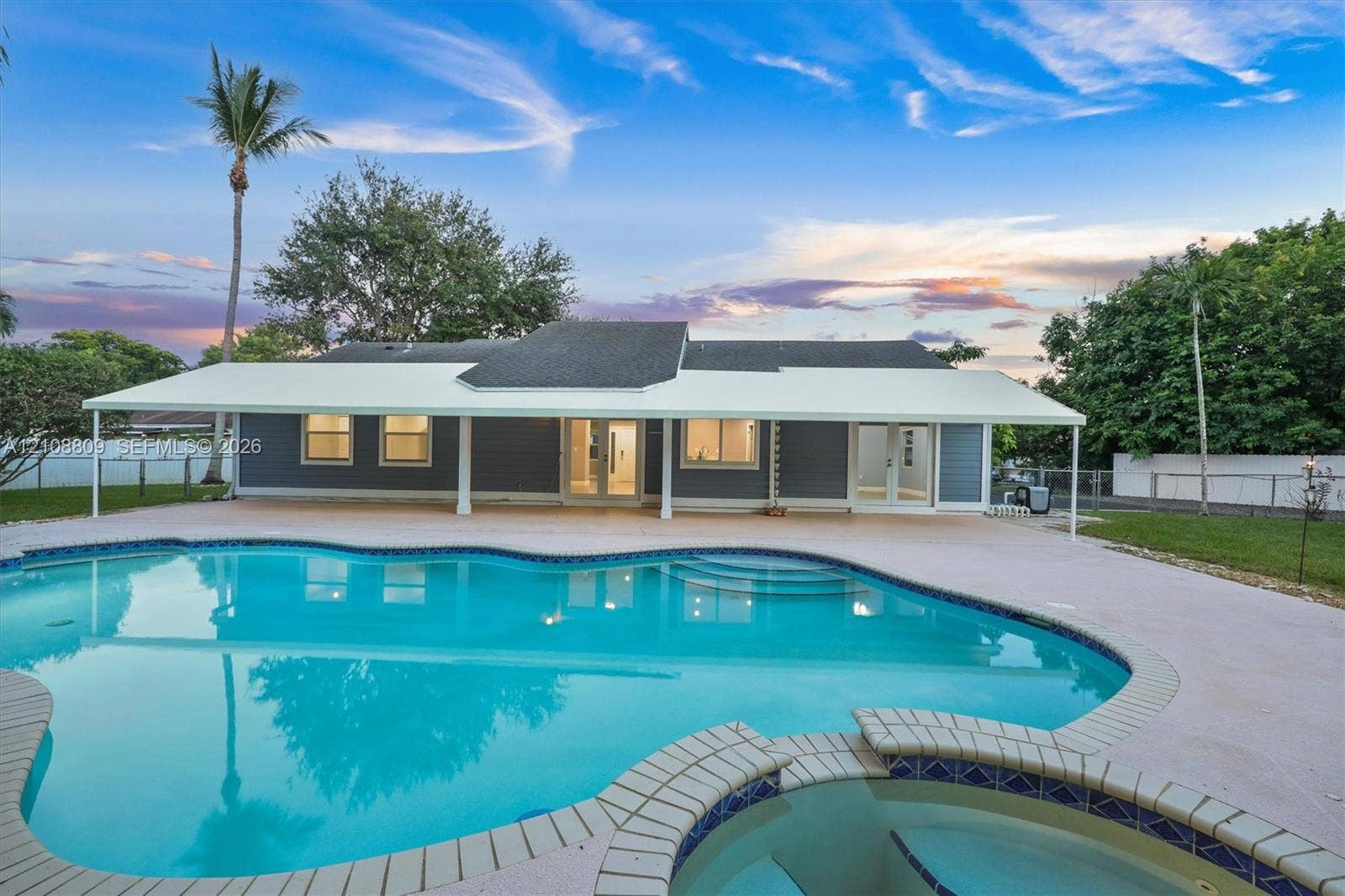 Exterior featuring a covered patio, swimming pool, integrated spa, and siding finish