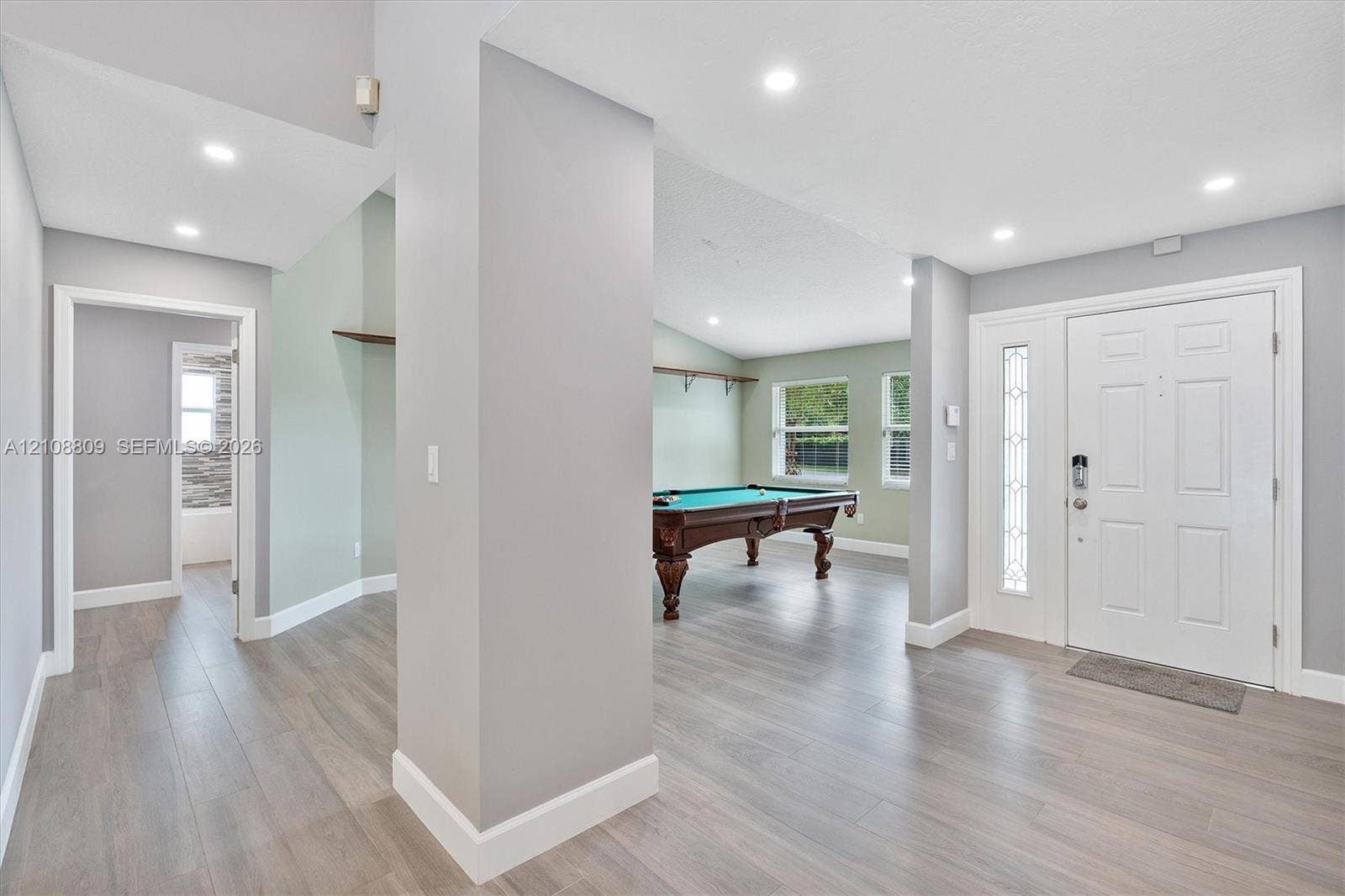 Entryway featuring wood-finish flooring, recessed lighting, and a front door with decorative glass side-lite