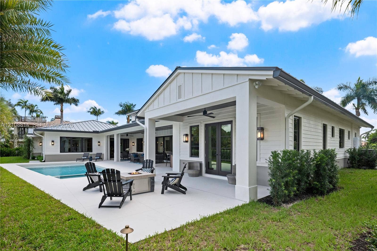 Covered patio featuring board and batten siding, recessed ceiling lighting, attached ceiling fan, and concrete hardscaping surrounding an in-ground swimming pool